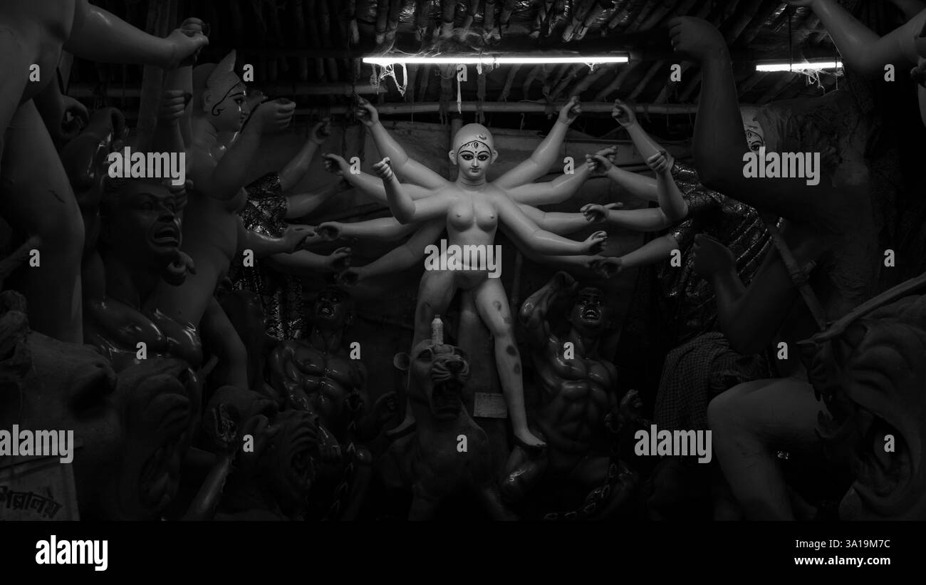 Wo Kunst auf Hingabe trifft – Kumartulis geschickte Hände hauchen Maa Durga Leben ein und schaffen mit jedem Schlag Göttlichkeit. Stockfoto