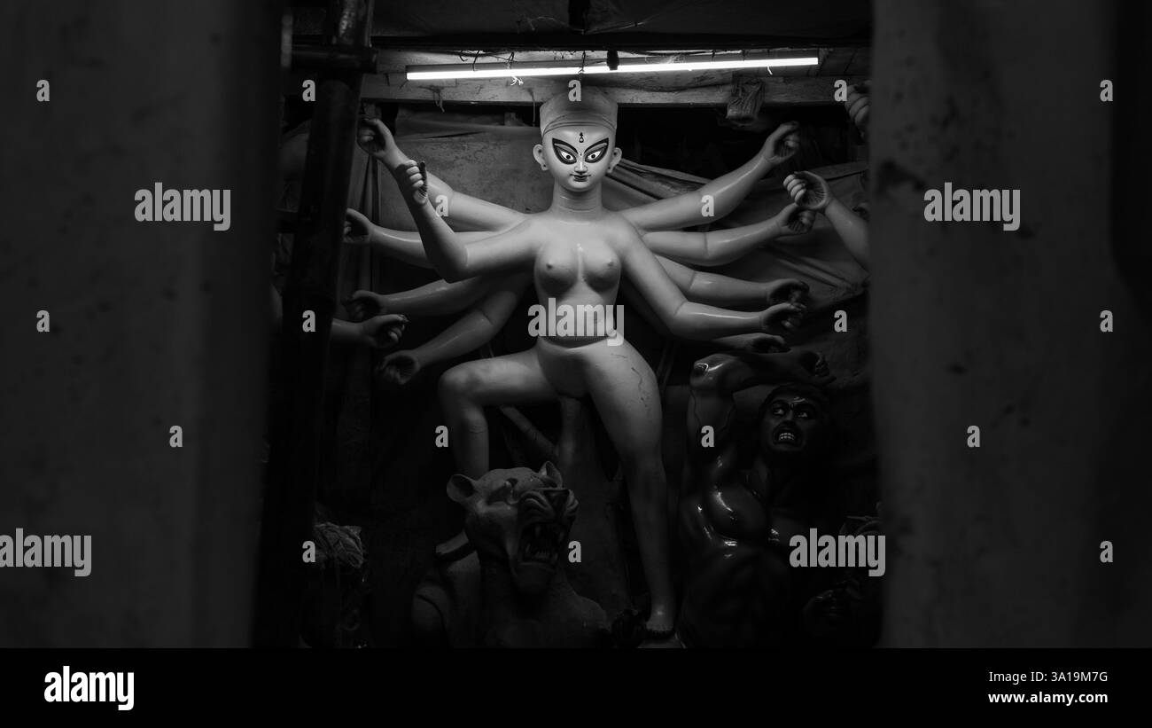 Wo Kunst auf Hingabe trifft – Kumartulis geschickte Hände hauchen Maa Durga Leben ein und schaffen mit jedem Schlag Göttlichkeit. Stockfoto