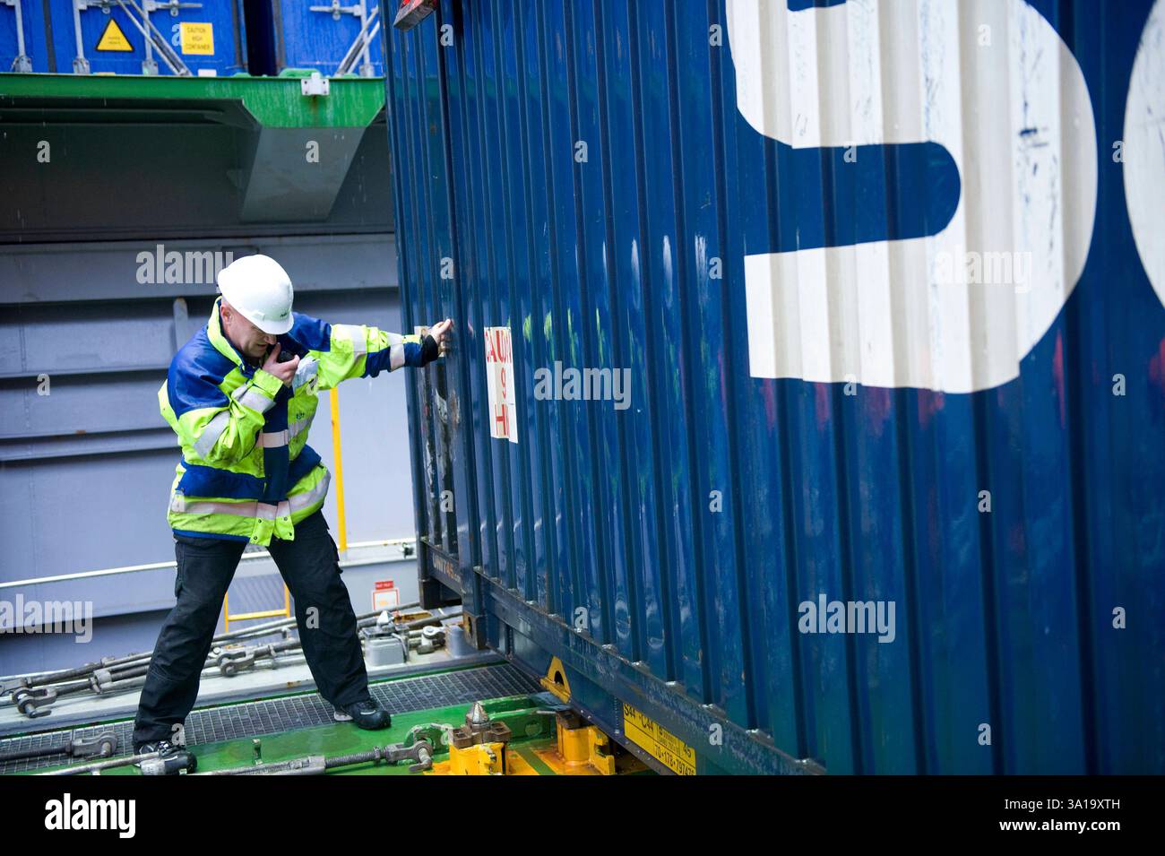 Deck & Load Master – Sichern eines Containers. Der Load & DeckMaster an Bord der MS Flintercape sichert einen Container kurz vor seiner Reise von Rotterdam, Niederlande nach Sundvall, Schweden. Rotterdam NLD - Sundsvall SE Containerschiff MS Flintercape Noordzee, Baltische Zee, Golf va Niederlande Copyright: XGuidoxKoppesxPhotox Stockfoto