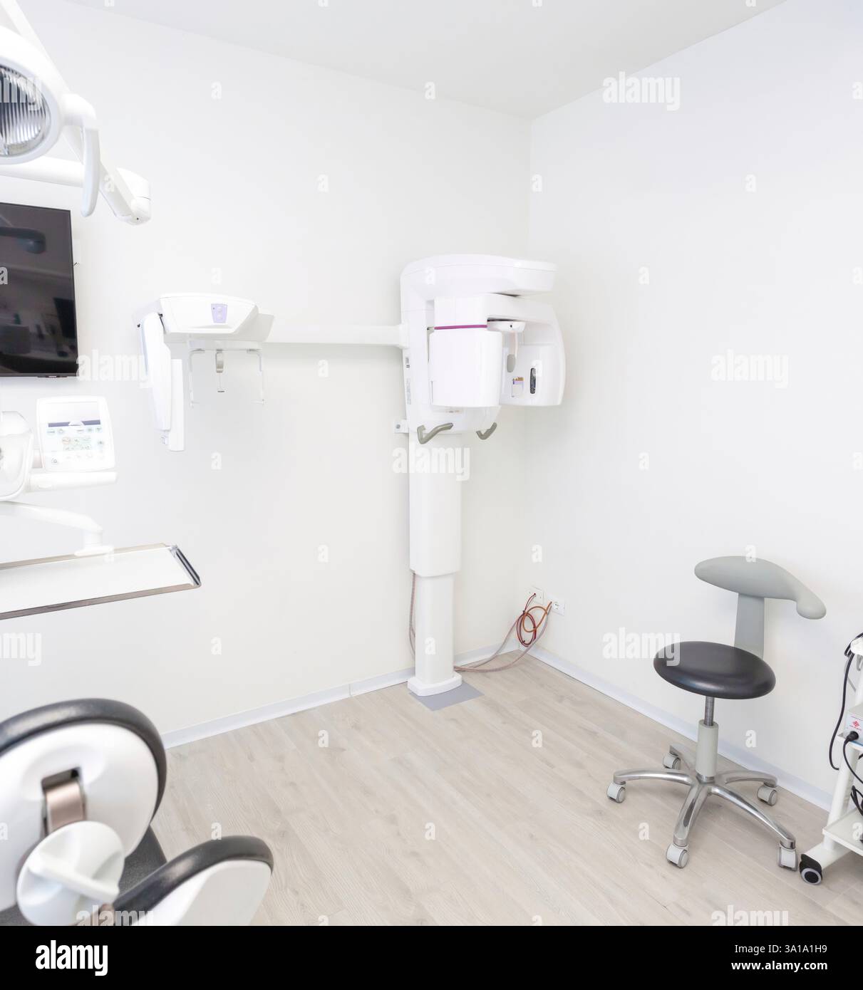 Innenraum einer hellen, modernen Zahnklinik mit einem Orthopantomographen, anderen Spezialgeräten und einer sauberen, professionellen Umgebung Stockfoto