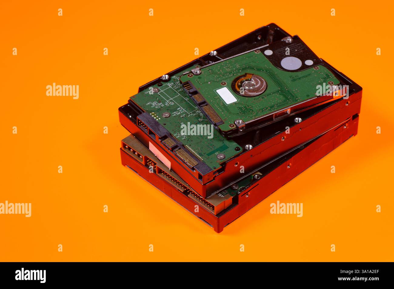 Ein Stapel von Computerfestplatten auf orangefarbenem Hintergrund Stockfoto