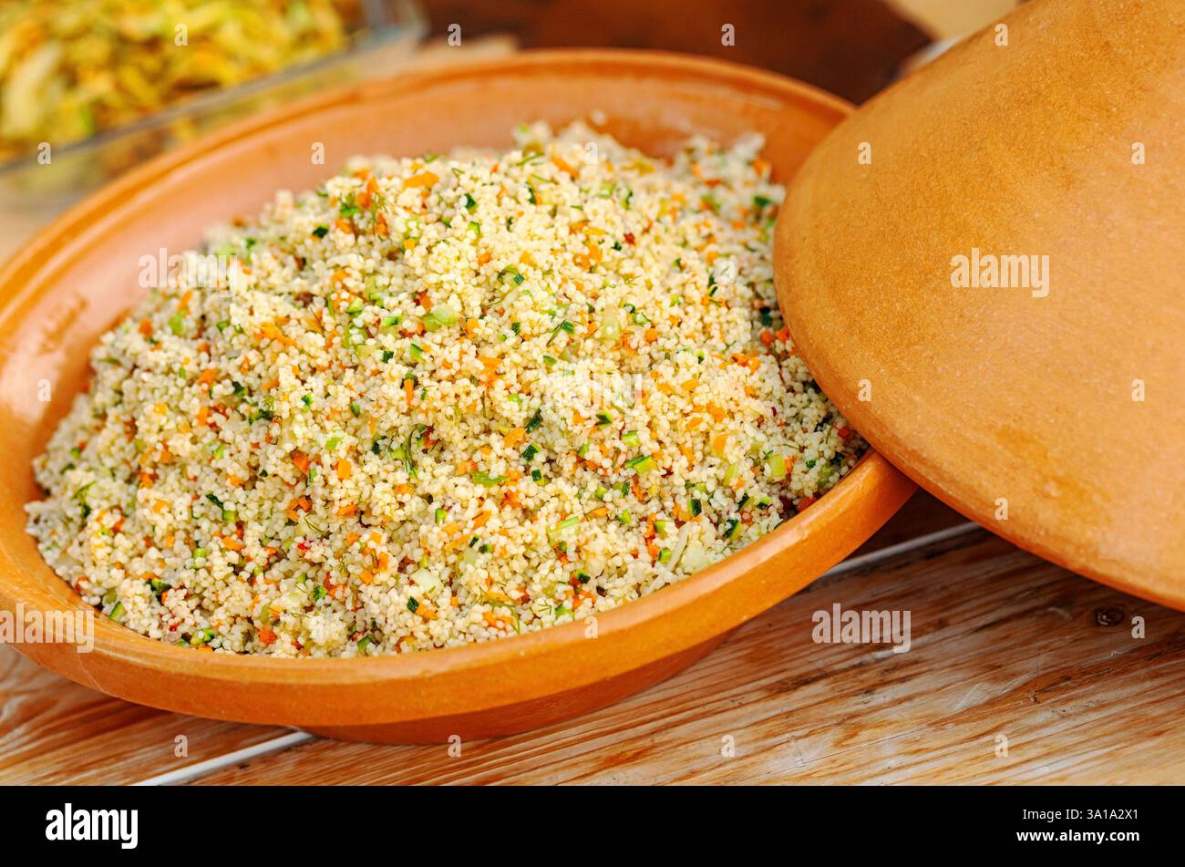 Gemüse-Tajine mit Couscous auf Holztisch. Stockfoto