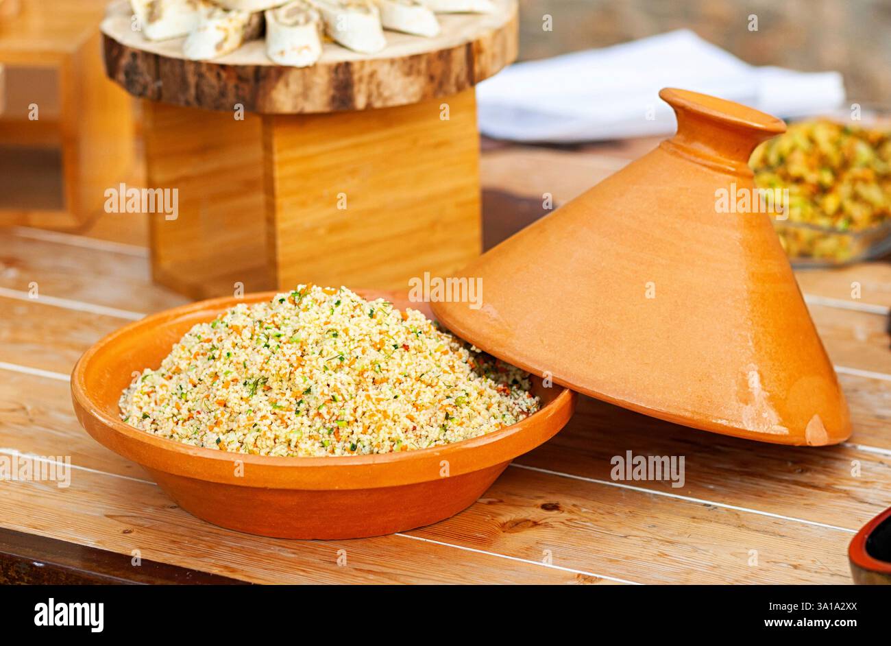 Gemüse-Tajine mit Couscous auf Holztisch. Stockfoto
