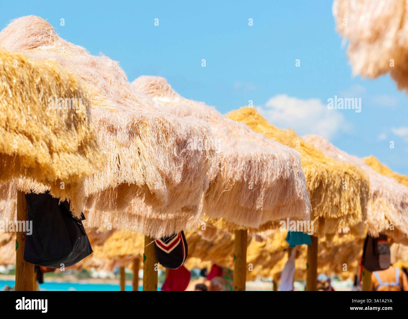 Strand schöne strohgedeckten Sonnenschirmen und leuchtend türkisfarbene Meer, tolle Erholung und Entspannung. Stockfoto