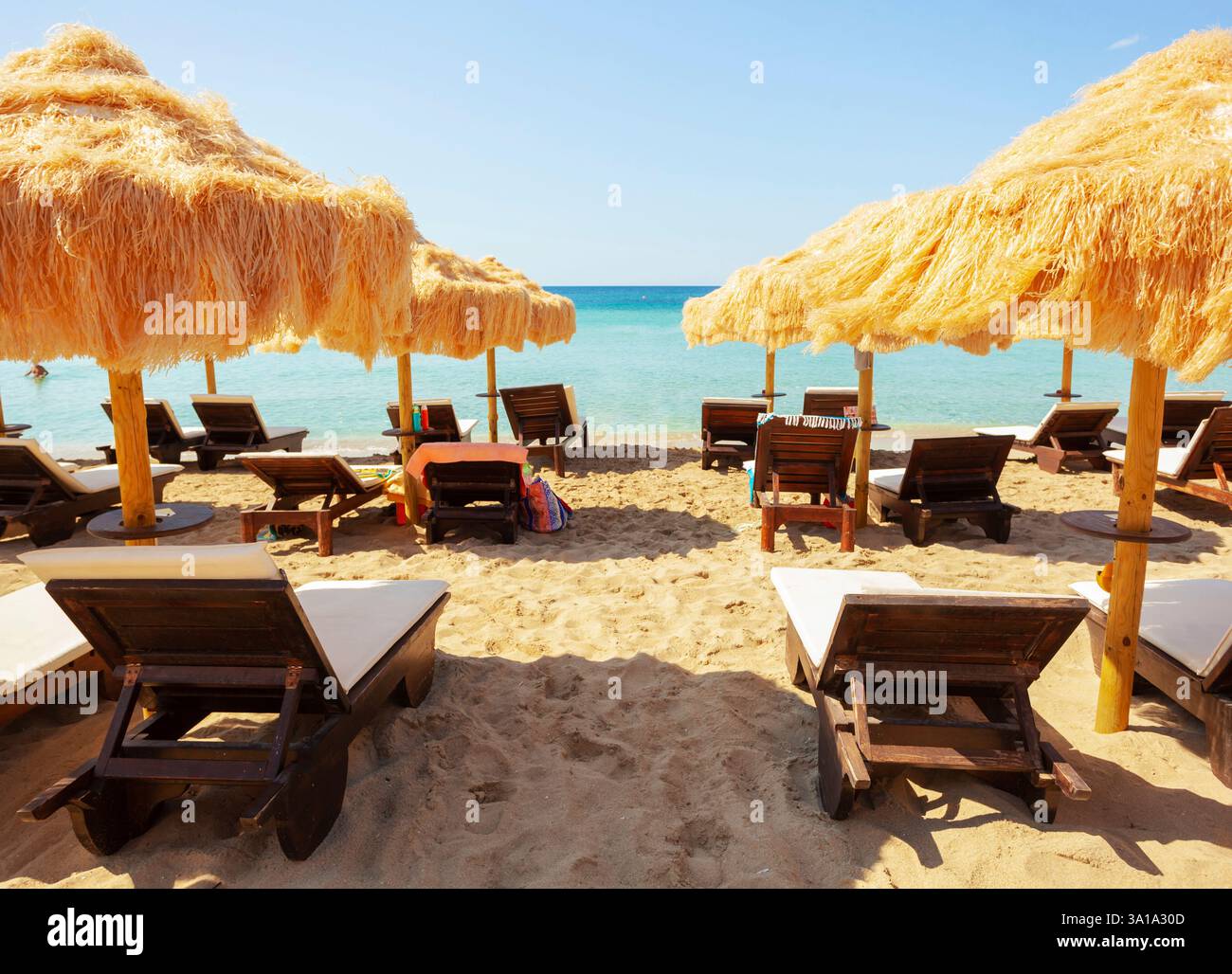 Strand schöne strohgedeckten Sonnenschirmen und leuchtend türkisfarbene Meer, tolle Erholung und Entspannung. Stockfoto