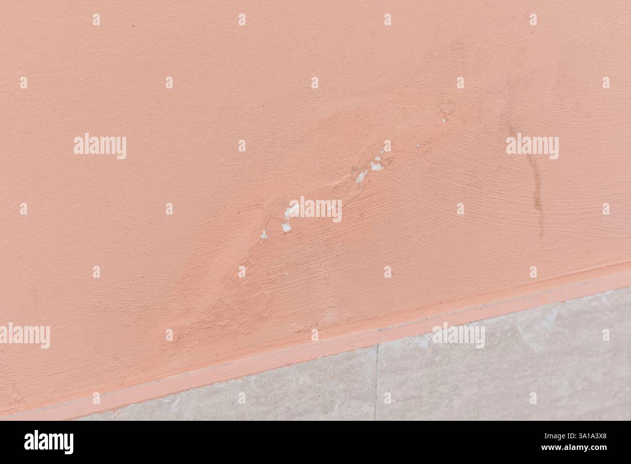 Die abblätternde Farbe an dieser Wand ist ein Anzeichen für Wasserschäden, was auf die Notwendigkeit einer Gebäudesanierung hinweist Stockfoto