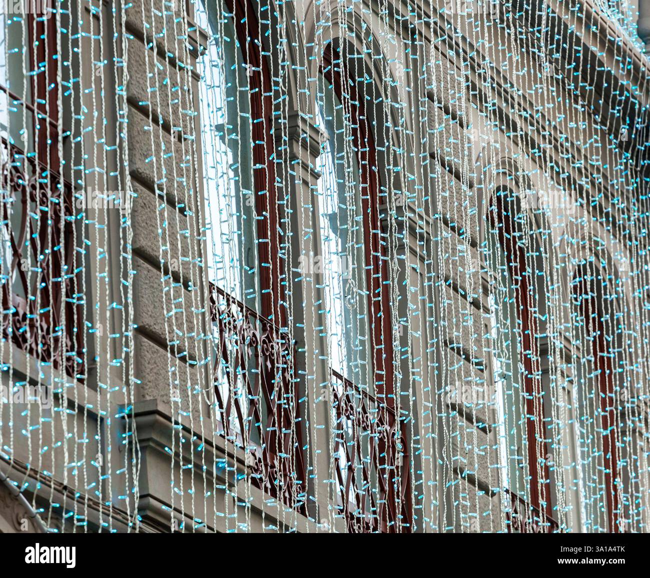 Blaue weihnachtslichter hängen an einer Gebäudefassade und sorgen für festliche Stimmung Stockfoto