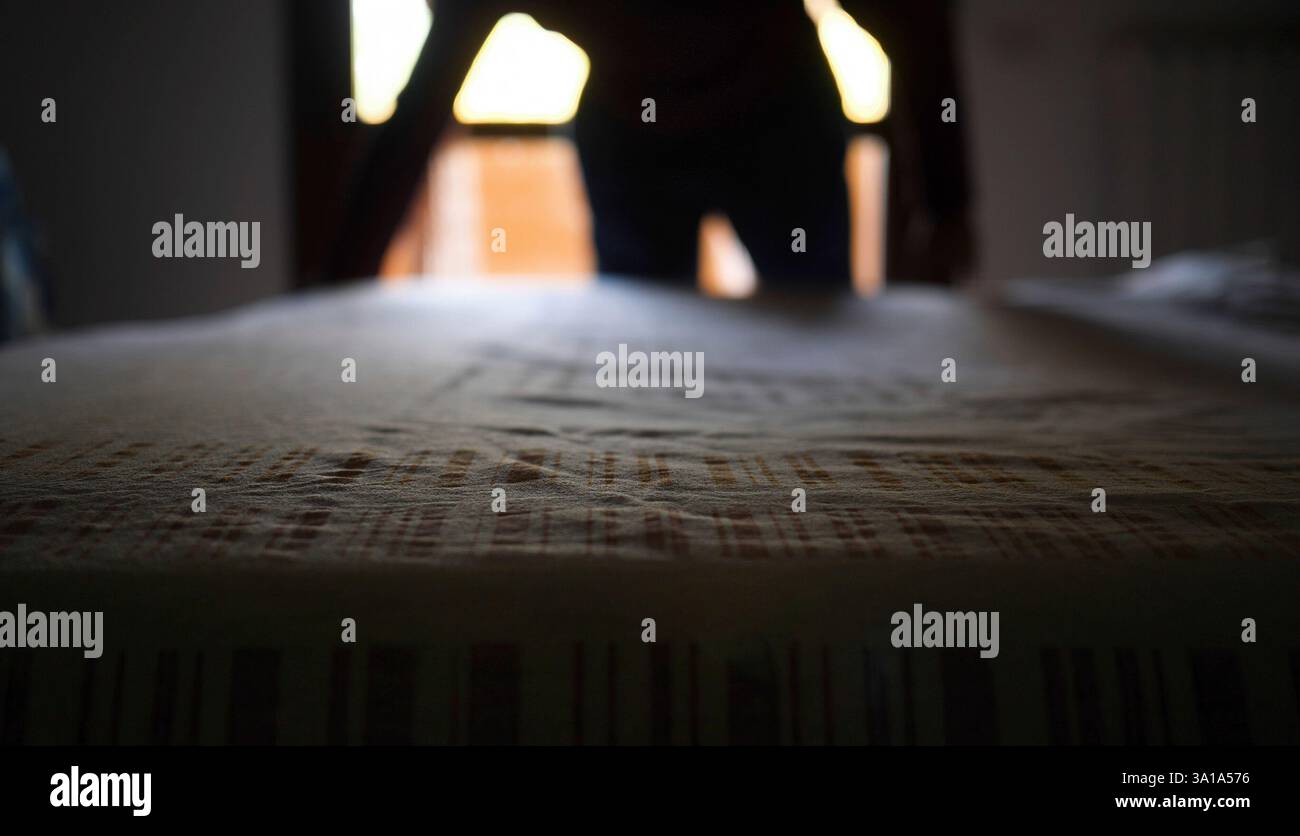 Der Erwachsene Mann timmt das Bett mit einem Baumwolltuch. Authentische moderne und echte Szene. Stockfoto