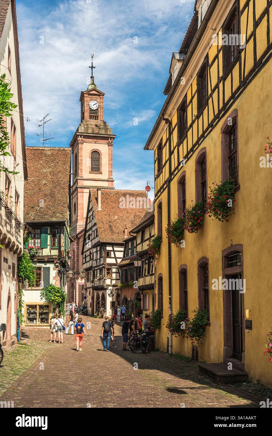 Gasse mit Blick auf die Kirche in der Altstadt von Riquewihr, Elsass, Frankreich Stockfoto