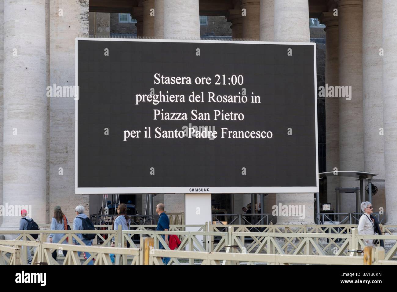 Petersplatz. Nachricht auf LED-Bildschirm vor der Kolonnade, die Gläubige einlädt, für Papst Franziskus Gesundheit während des Krankenhausaufenthalts zu beten. Vatikanstadt, Rom, Italien Stockfoto
