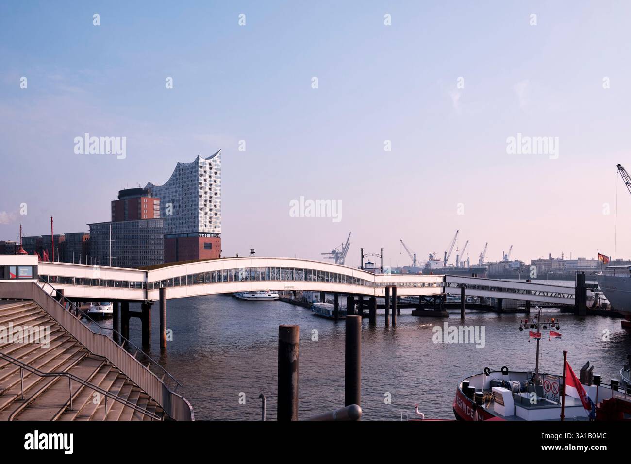 Überseebrücke im Hamburger Hafen, fotografiert von der Elbpromenade. Im Hintergrund sind die Elbphilharmonie und Teile der Sandtorhöft zu sehen Stockfoto