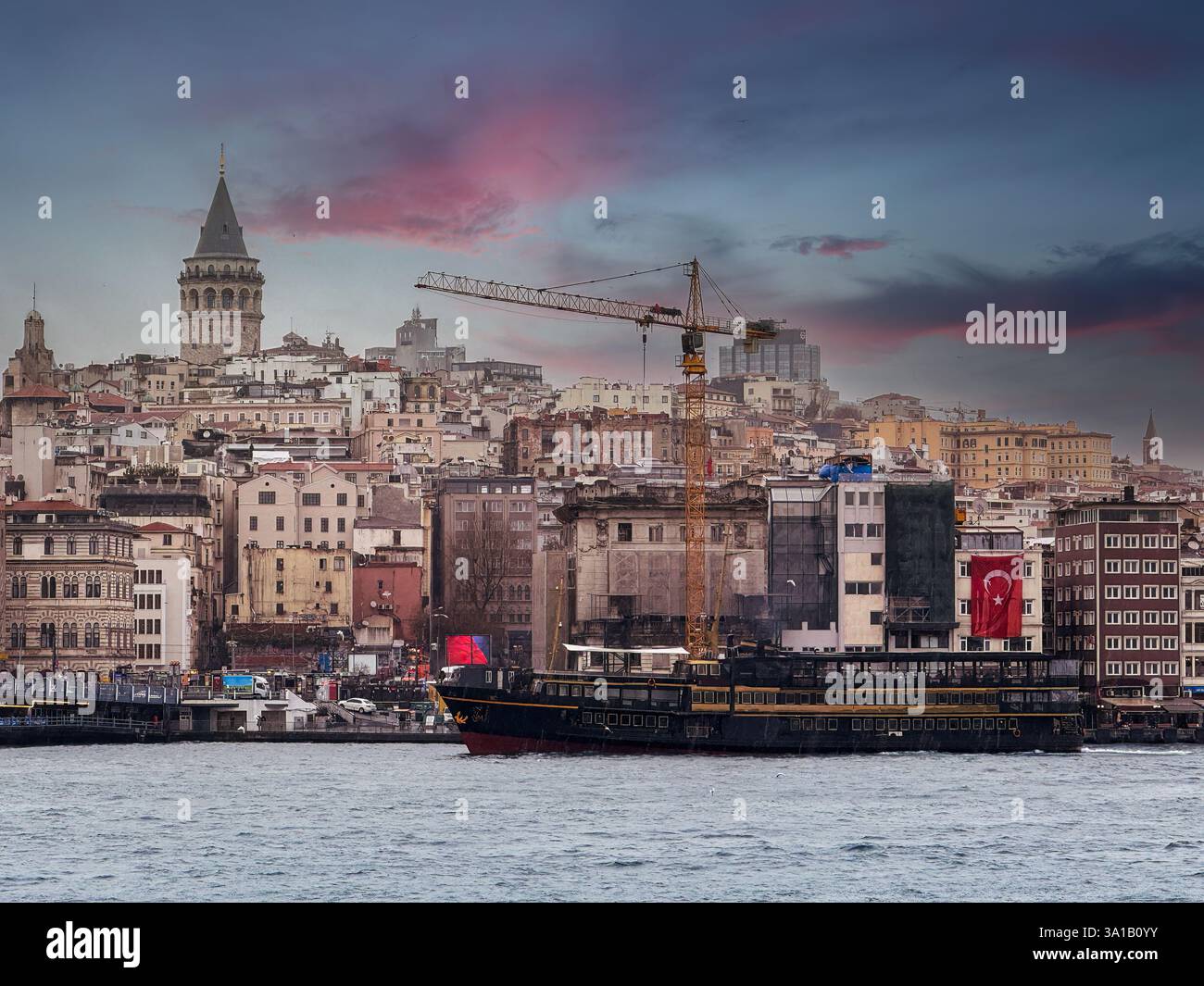 Malerische Aussicht auf Istanbul mit dem berühmten Galatenturm, den nahe gelegenen städtischen Gebäuden und dem Bosporus-Wasser unter dem Wolkenhimmel, Istanbul, Türkei. Stockfoto