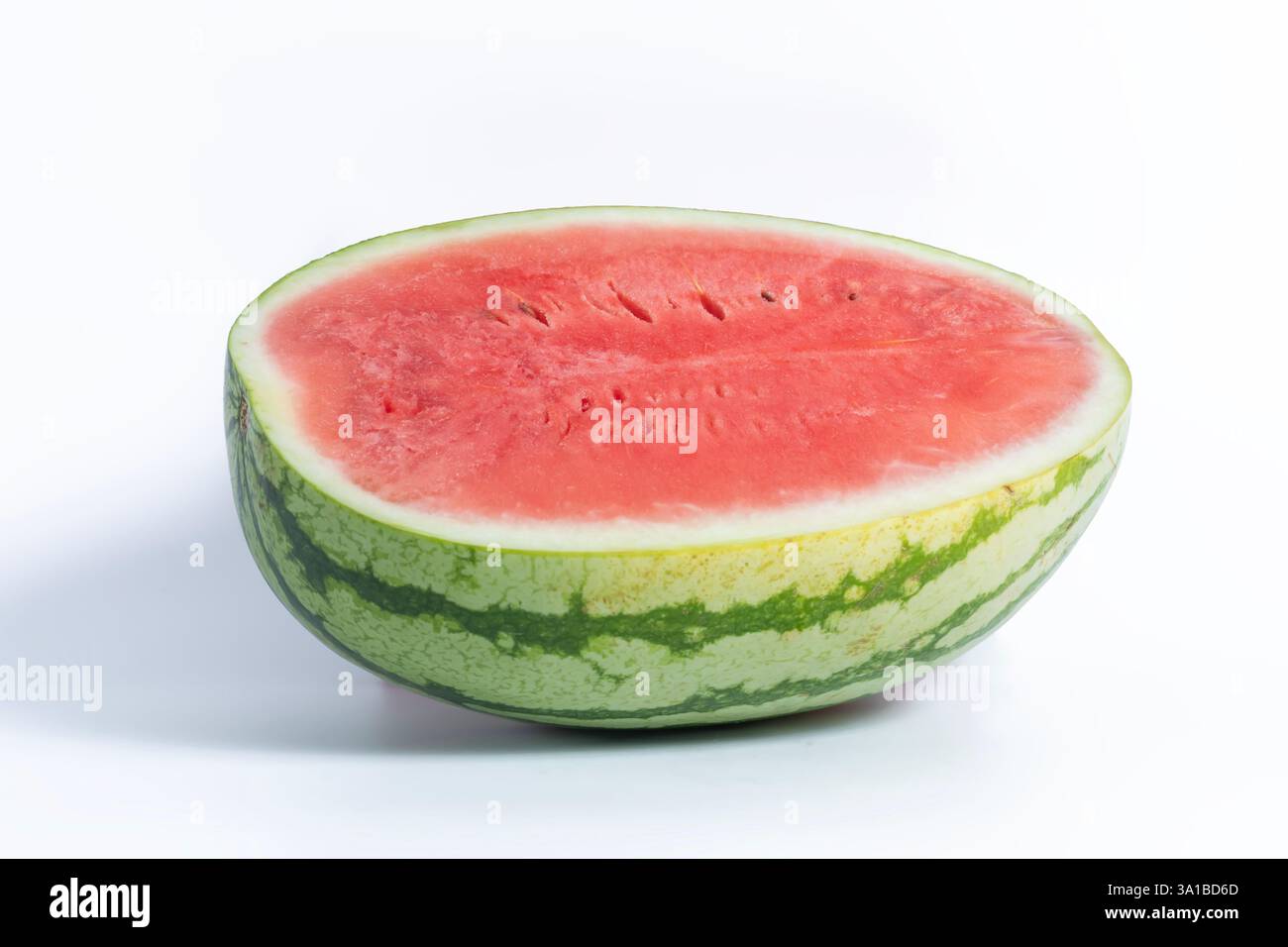 Eine in zwei Hälften geschnittene Wassermelone mit einem leuchtend roten Innenraum und einer markanten grün gestreiften Außenhaut, die Sommerfrische und gesunde Ernährung symbolisiert. Stockfoto