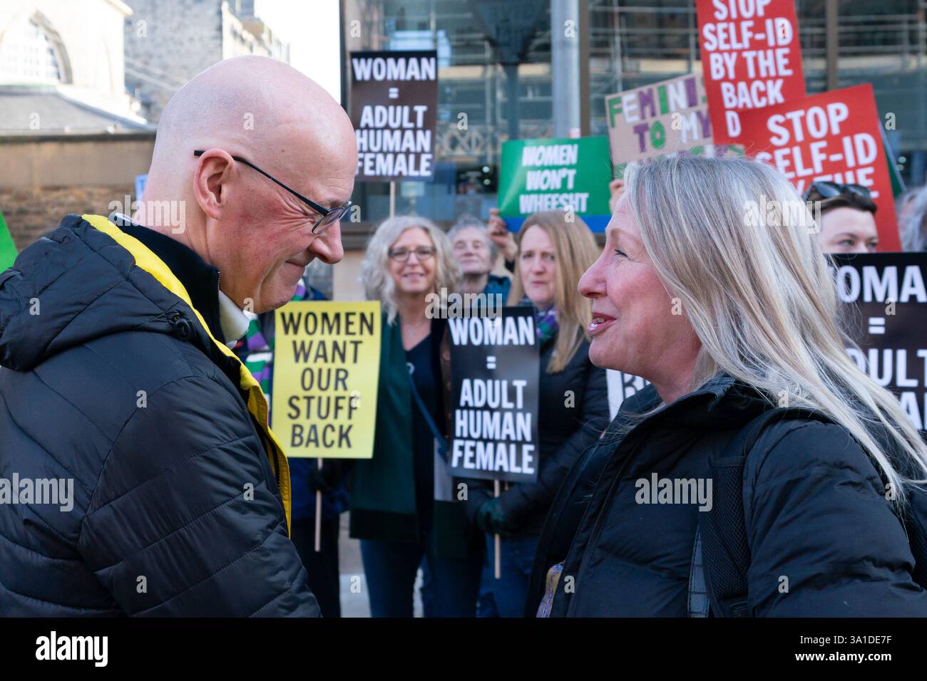 Edinburgh, Schottland, Großbritannien. März 2025. Die Frauenpro-Frauengruppe Schottland veranstaltete vor dem Veranstaltungsort des Internationalen Frauentags der SNP in Edinburgh eine Proteste, an der die Referenten First Minister John Swinney und die ehemalige First Ministerin Nicola Sturgeon teilnahmen. Die Demonstranten sind unglücklich darüber, dass die SNP keinen Unterschied zwischen Transsexuellen und Frauen macht und welche Auswirkungen diese Politik auf die rein weiblichen Räume hat. Herr Swinney sprach mit Marion Calder, Direktorin für Frauen Schottland, bevor er an der Veranstaltung teilnahm. John Swinney spricht mit Marion Calder. Iain Masterton/Alamy Live News. Stockfoto