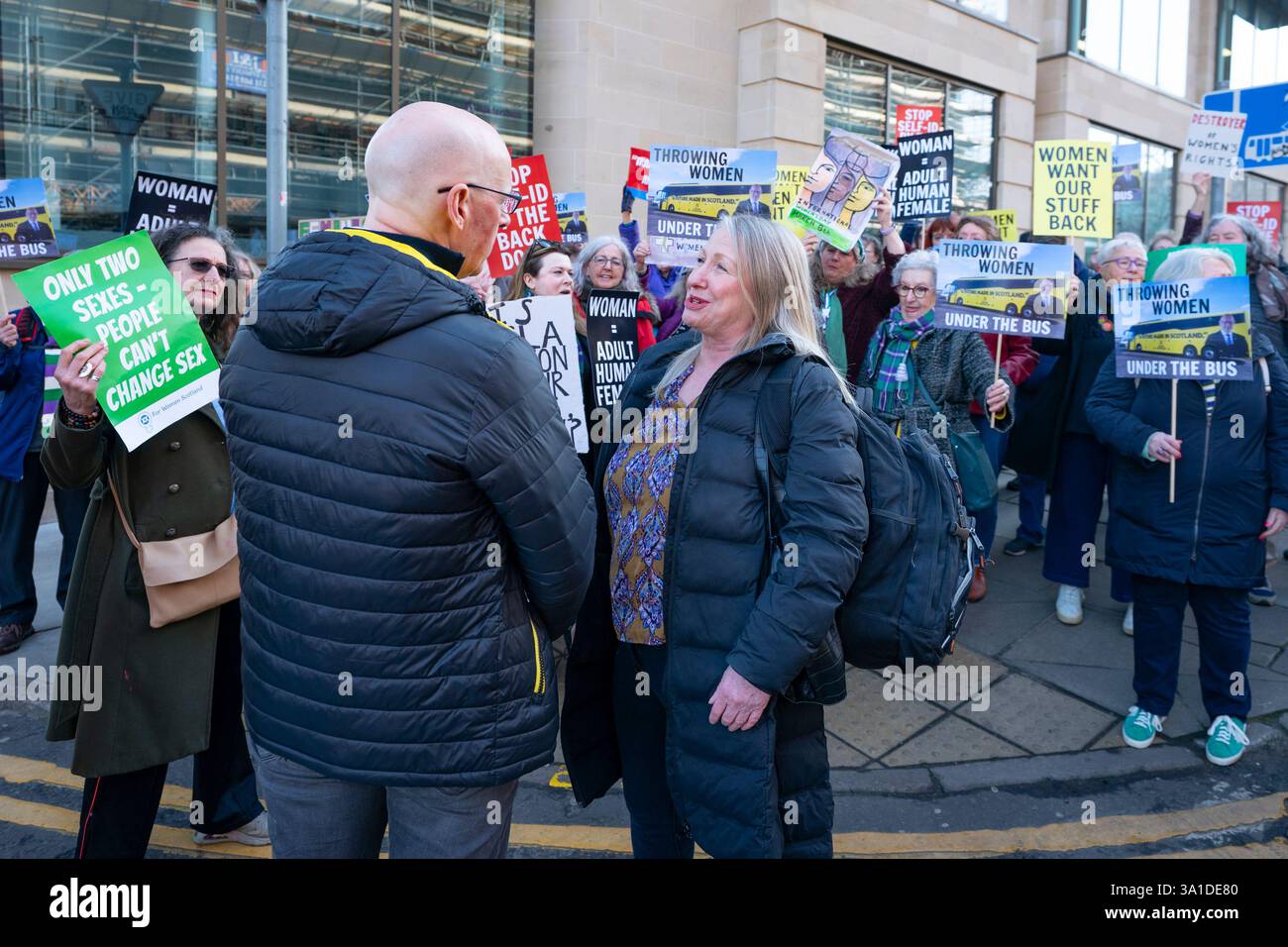 Edinburgh, Schottland, Großbritannien. März 2025. Die Frauenpro-Frauengruppe Schottland veranstaltete vor dem Veranstaltungsort des Internationalen Frauentags der SNP in Edinburgh eine Proteste, an der die Referenten First Minister John Swinney und die ehemalige First Ministerin Nicola Sturgeon teilnahmen. Die Demonstranten sind unglücklich darüber, dass die SNP keinen Unterschied zwischen Transsexuellen und Frauen macht und welche Auswirkungen diese Politik auf die rein weiblichen Räume hat. Herr Swinney sprach mit Marion Calder, Direktorin für Frauen Schottland, bevor er an der Veranstaltung teilnahm. John Swinney spricht mit Marion Calder. Iain Masterton/Alamy Live News. Stockfoto