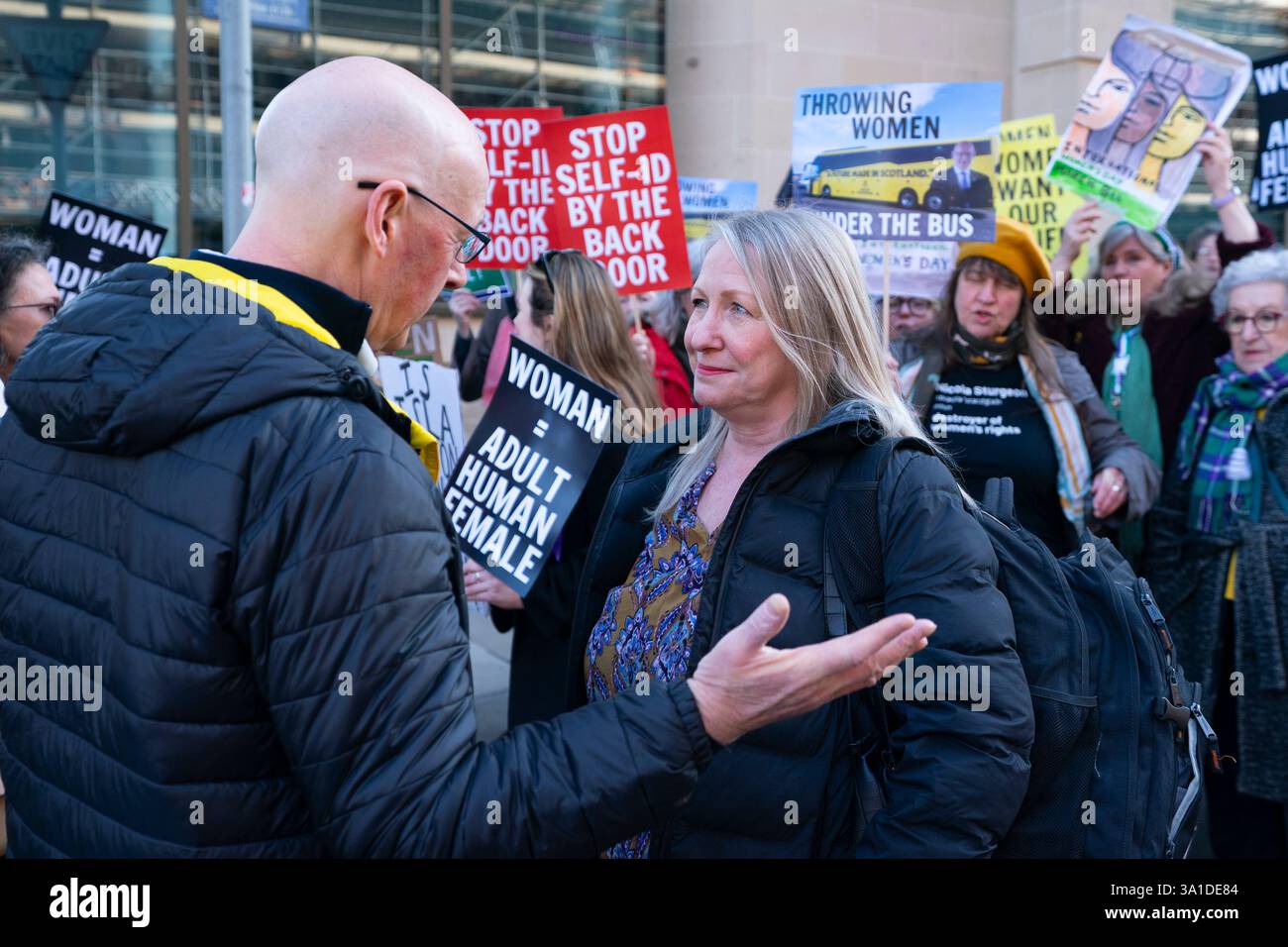 Edinburgh, Schottland, Großbritannien. März 2025. Die Frauenpro-Frauengruppe Schottland veranstaltete vor dem Veranstaltungsort des Internationalen Frauentags der SNP in Edinburgh eine Proteste, an der die Referenten First Minister John Swinney und die ehemalige First Ministerin Nicola Sturgeon teilnahmen. Die Demonstranten sind unglücklich darüber, dass die SNP keinen Unterschied zwischen Transsexuellen und Frauen macht und welche Auswirkungen diese Politik auf die rein weiblichen Räume hat. Herr Swinney sprach mit Marion Calder, Direktorin für Frauen Schottland, bevor er an der Veranstaltung teilnahm. John Swinney spricht mit Marion Calder. Iain Masterton/Alamy Live News. Stockfoto