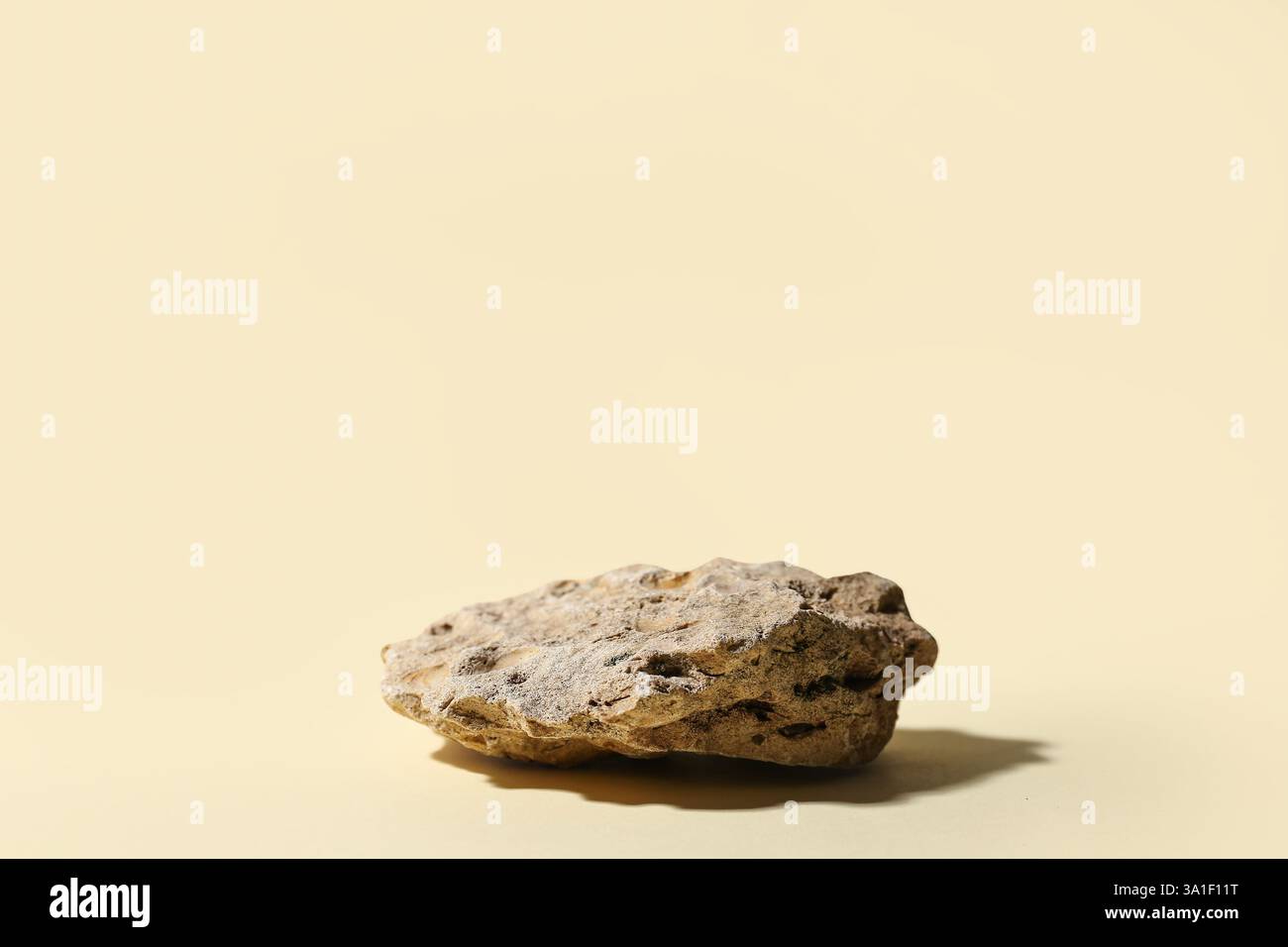 Dekoratives Steinpodium auf beigefarbenem Hintergrund Stockfoto