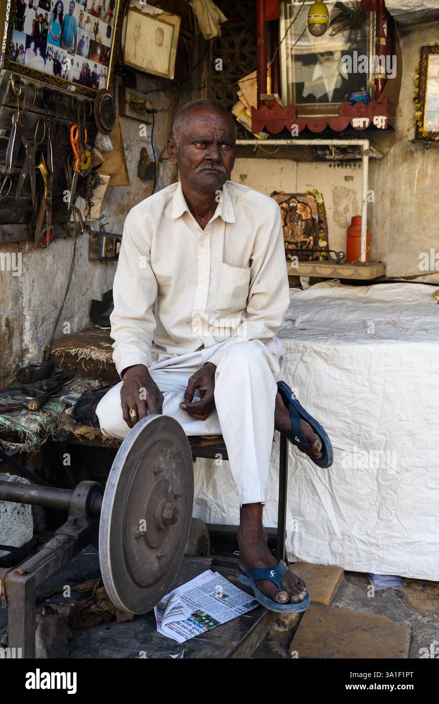 Jaisalmer, Rajasthan, Indien – 12. Februar 2025: Schere- und Messerschleifer sitzt in seiner offenen Werkstatt. Stockfoto