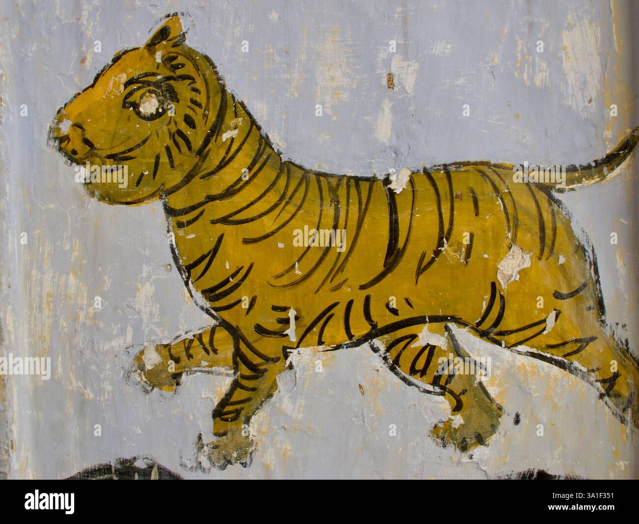 Ein verwittertes Wandgemälde eines Tigers, das Macht und göttlichen Schutz symbolisiert, gemeinhin mit der hinduistischen Göttin Durga und spiritueller Ikonographie assoziiert. Stockfoto