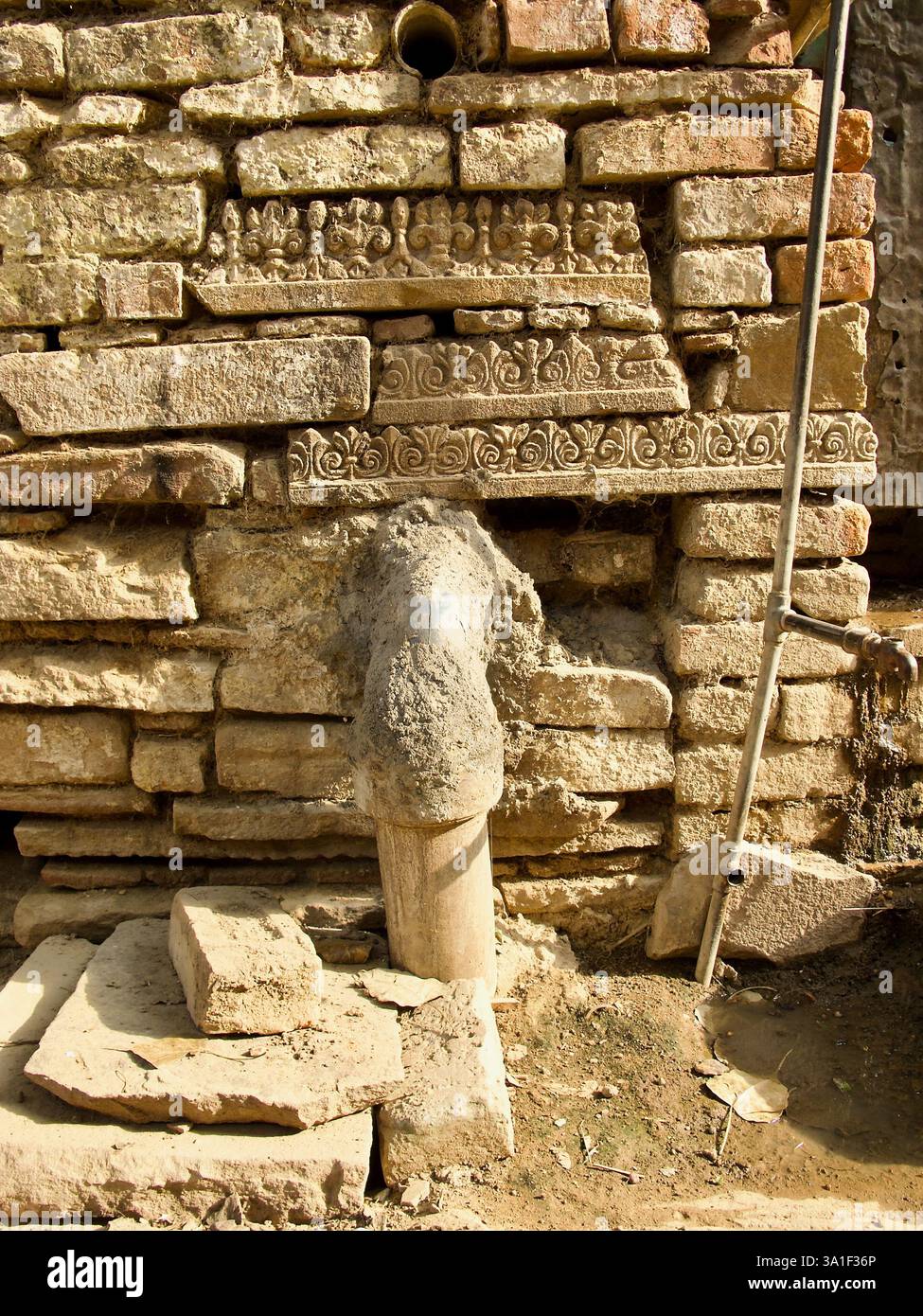 Geschichtsträchtige Schichten in Varanasi alten Straßenmauern, die komplizierte Schnitzereien und architektonische Relikte vergangener Jahrhunderte enthüllen. Stockfoto