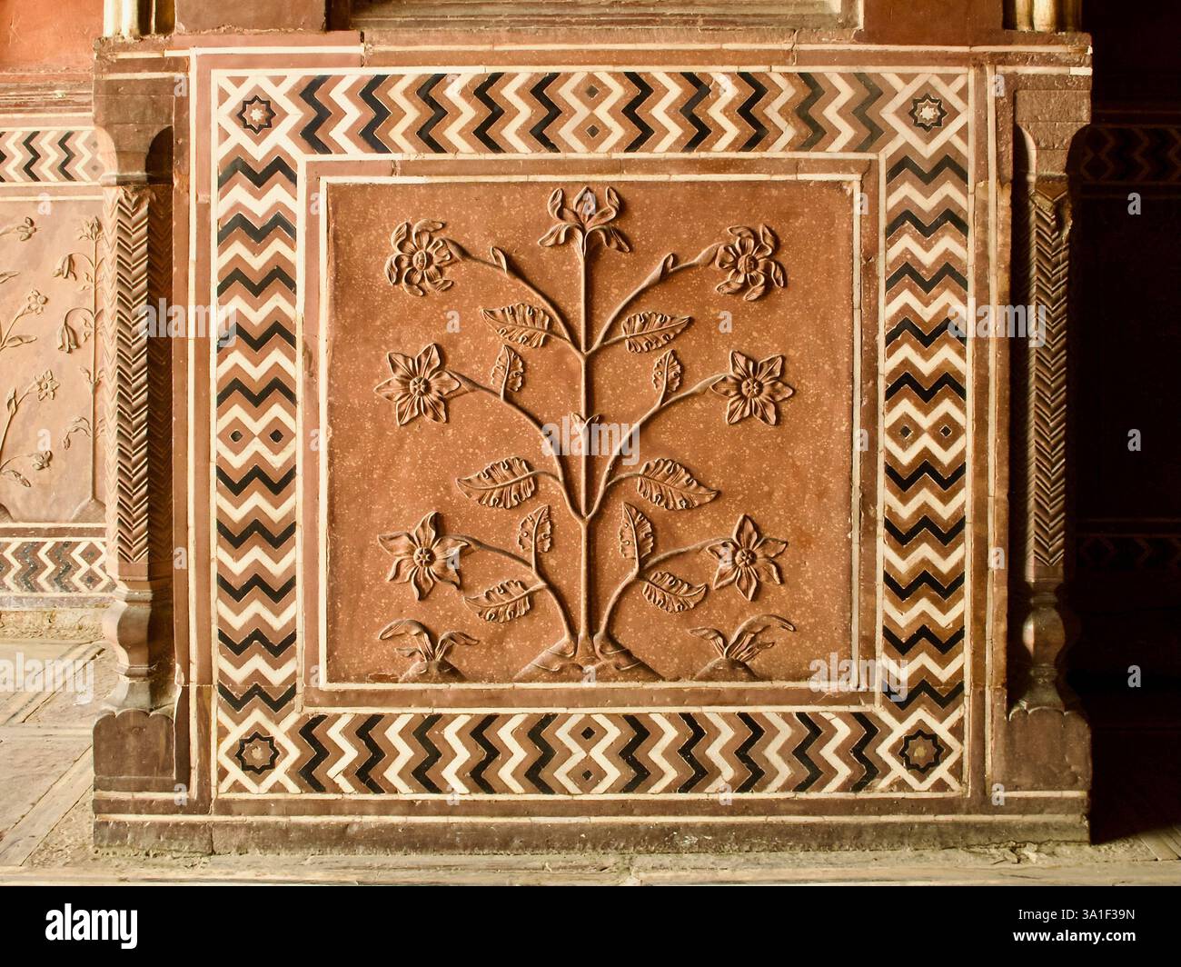 Blumenreliefschnitzerei in rotem Sandstein mit Zickzack-Marmor-Intarsien, Taj Mahal Komplex, Agra. Stockfoto