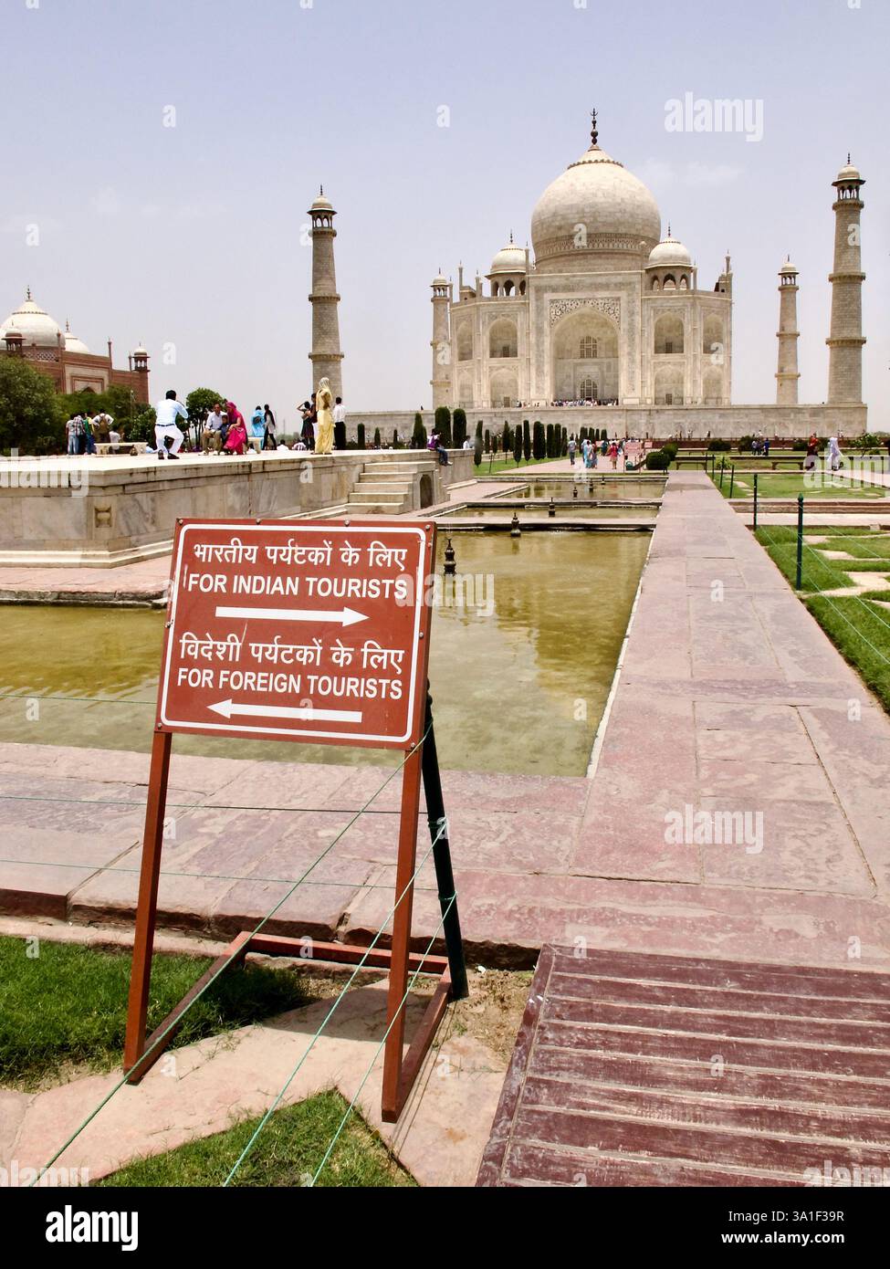 Das Touristenschild am Taj Mahal weist indische und ausländische Besucher auf separaten Wegen am Eingang des berühmten Mogul-Monuments in Agra an. Stockfoto