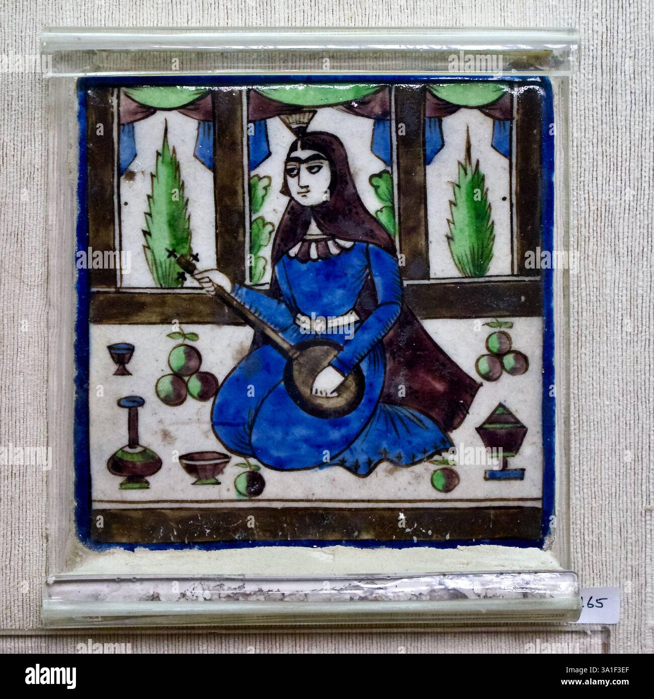 Persische Keramikfliese im Qajar-Stil, die eine Frau mit einem Setar darstellt, fotografiert in einem dekorativen Kunstgeschäft in Delhi, Indien. Stockfoto