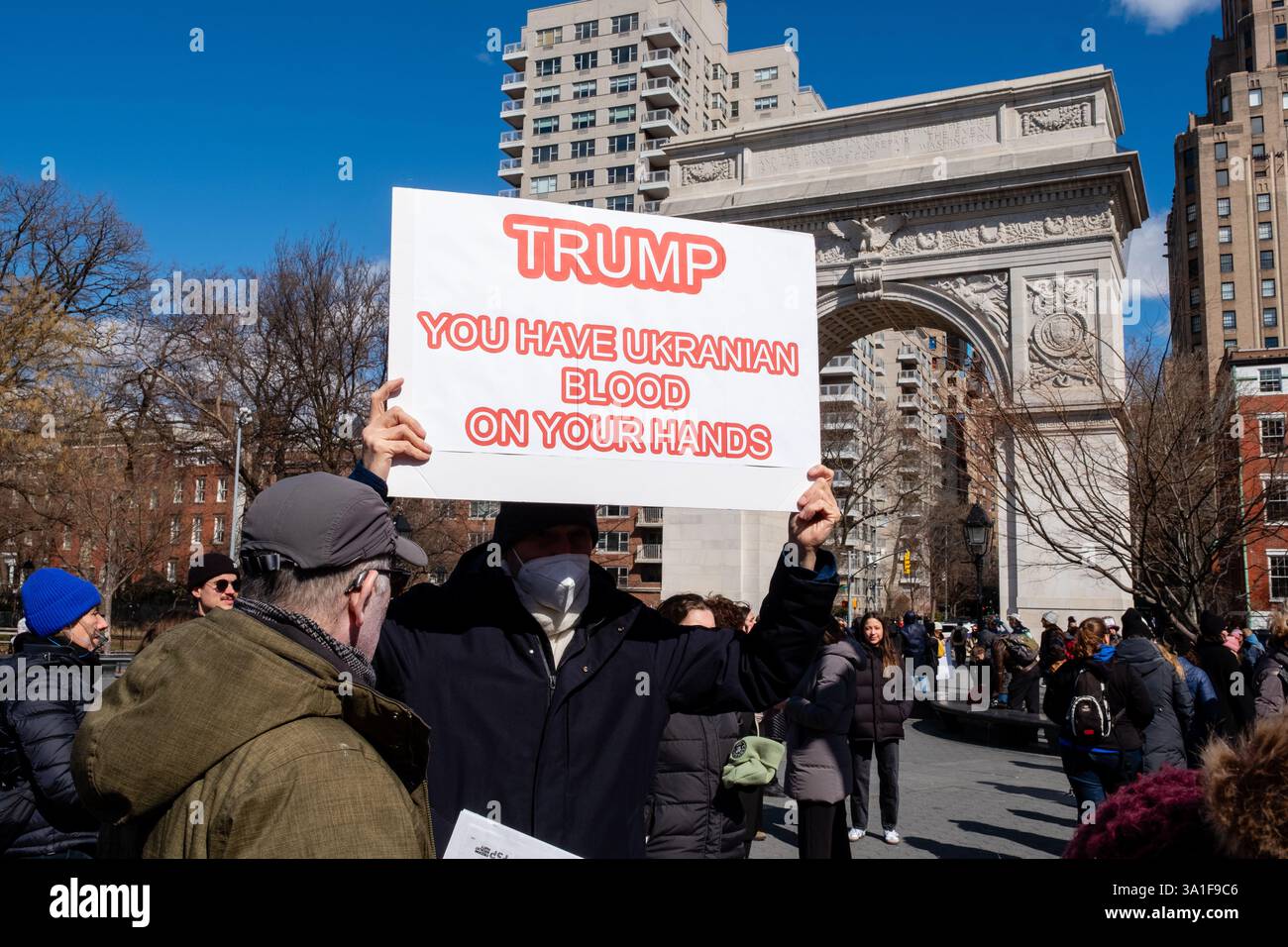 New York, NY, USA. März 2025. Tausende Frauen und Unterstützer versammelten sich im Washington Square Park zu einer Kundgebung und marschierten zum Union Square, um die Rechte von Frauen, Schwulen, Transgender und Menschenrechten am Internationalen Frauentag zu unterstützen. Ein Mann hält ein Schild mit der Aufschrift „Trump, du hast ukrainisches Blut an deinen Händen“. Quelle: Ed Lefkowicz/Alamy Live News Stockfoto