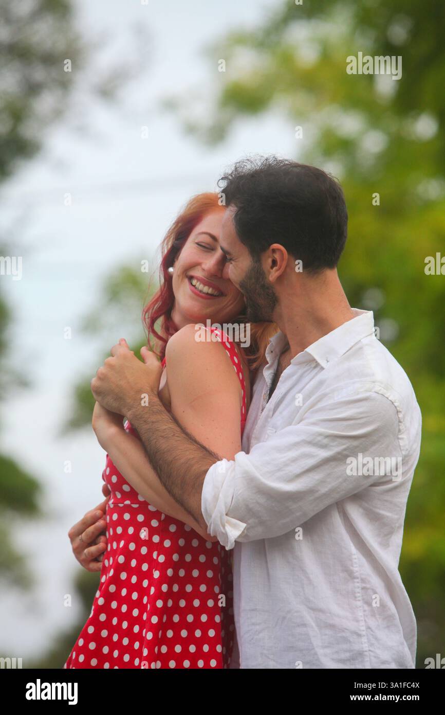 Porträt eines fröhlichen gemischten Paares im Park am Sommertag Stockfoto