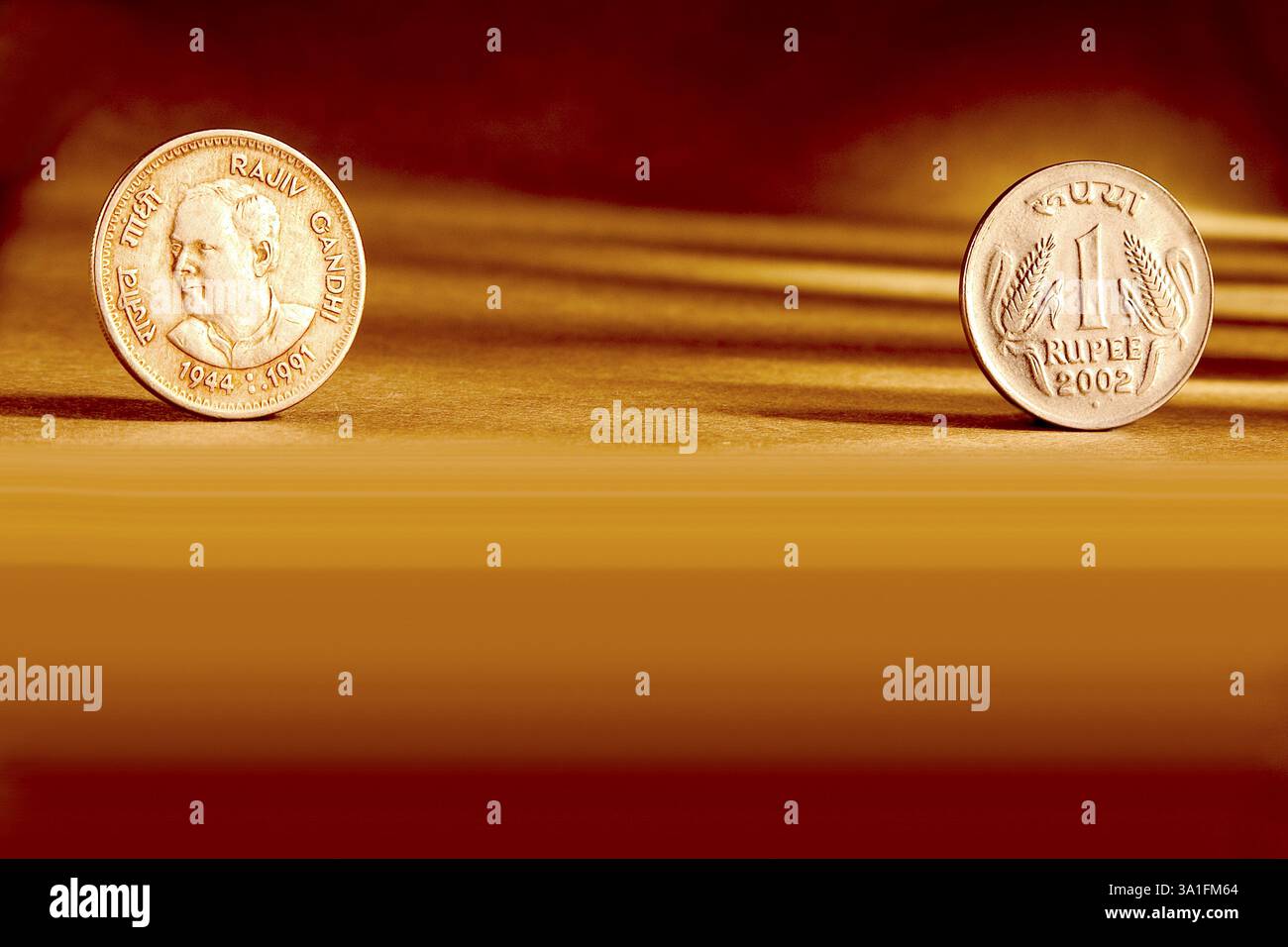 Doppeltes Paar indische Währung eine Rupie Münze Vorder- und Rückseite Weise geprägt Rajiv Gandhi 1944-1991 auf orangem Hintergrund Stockfoto