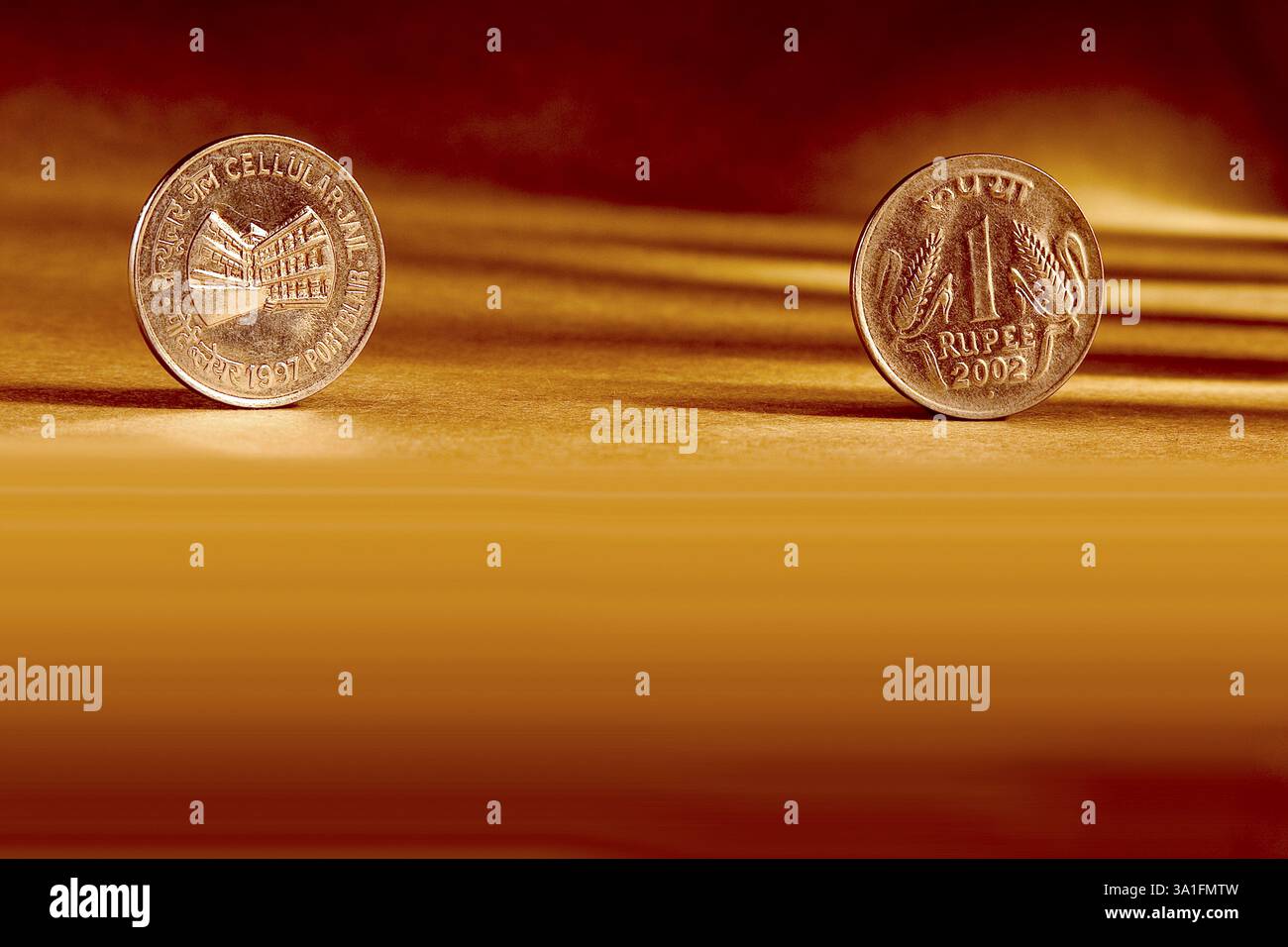 Doppeltes Paar indische Währung eine Rupie Münze Vorder- und Rückseite Weise geprägt Cellular Jail Port Blair 1997 auf orangem Hintergrund Stockfoto