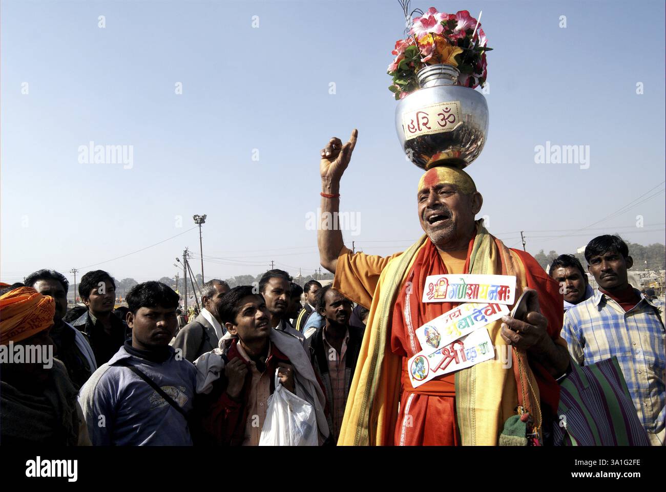 Ein heiliger, Sadhu balancierte ein Edelstahlglas mit Blumen auf dem Kopf, Ardh Kumbh Mela, eines der weltweit größten religiösen Feste in Allahabad, U Stockfoto