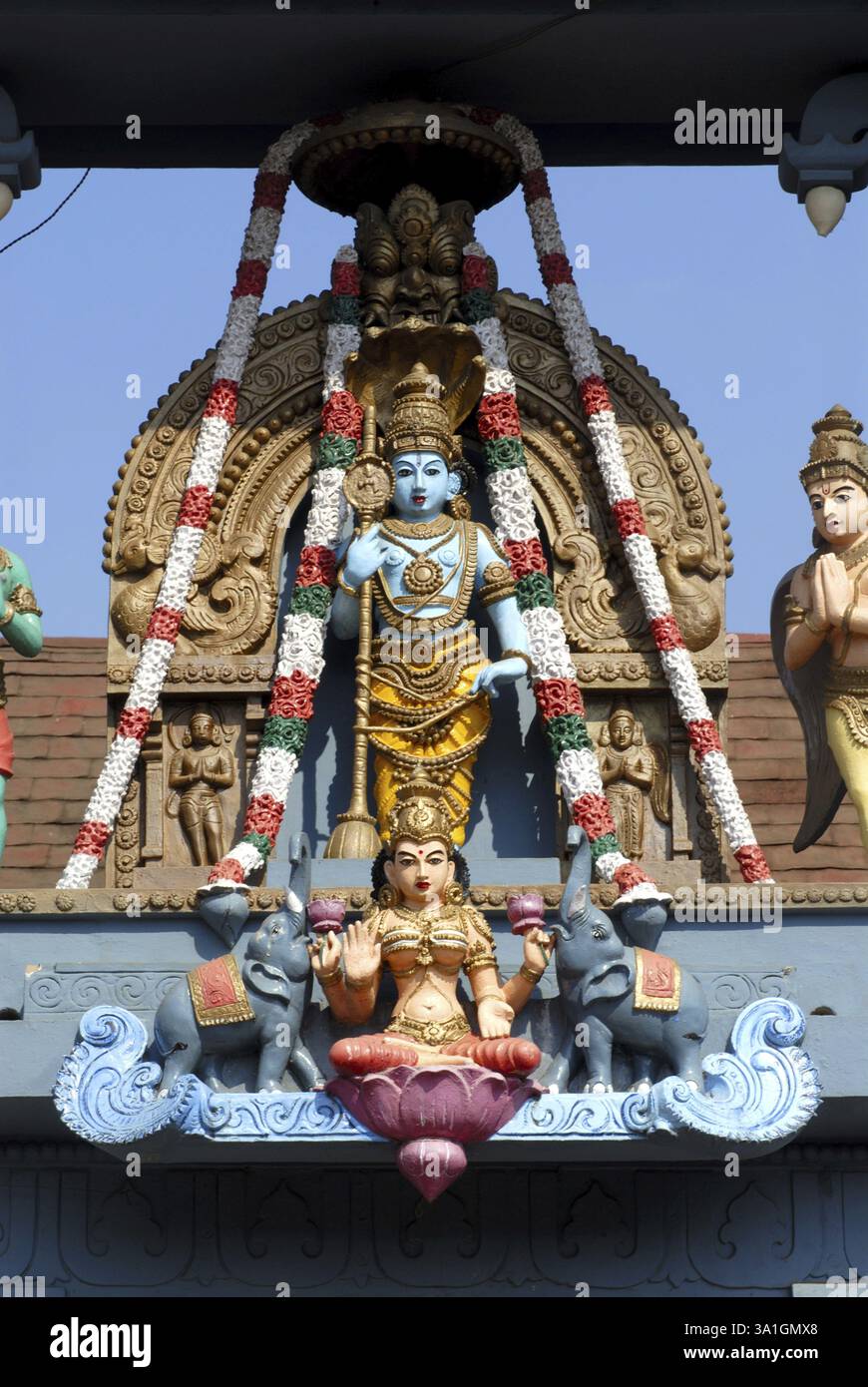 Idol des Herrn Vishnu und der Göttin Laxmi sitzen auf Lotus mit Elefanten auf beiden Seiten an der reich verzierten, farbenfrohen Fassade des Udupi Sri Krishna Temp Stockfoto
