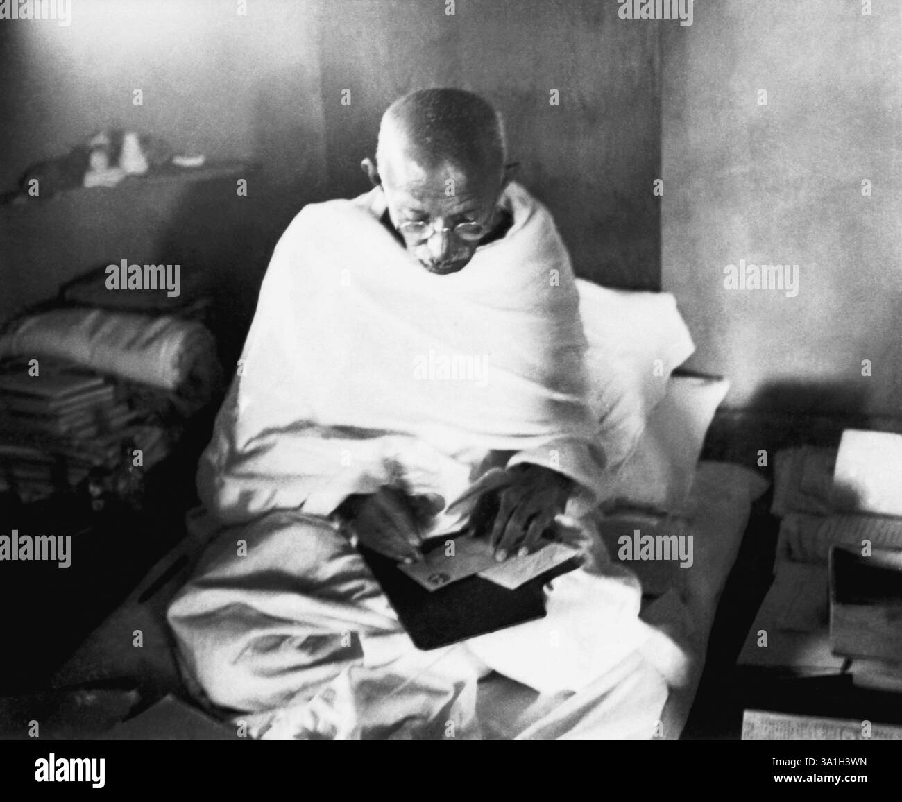 Mahatma Gandhi schreibt eine Adresse auf einem Umschlag in seiner Hütte in Sevagram Ashram, 1944 KEIN MR Stockfoto