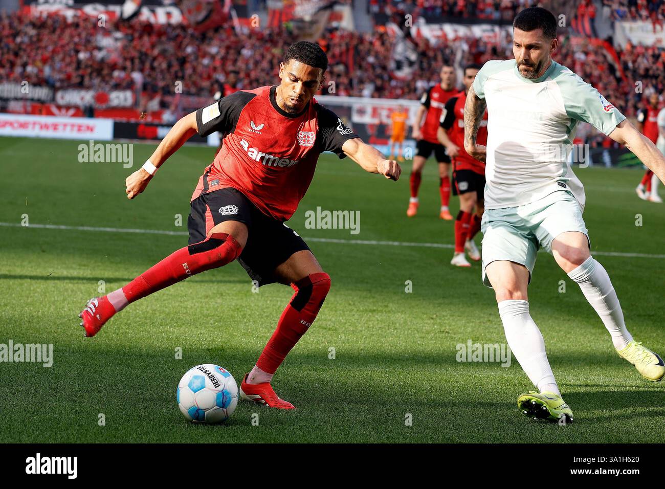 Leverkusen, Deutschland. März 2025. Amine Adli(L) von Bayer 04 Leverkusen streitet mit Anthony Jung vom SV Werder Bremen während des ersten Liga-Fußballspiels zwischen Bayer 04 Leverkusen und SV Werder Bremen am 8. März 2025 in Leverkusen. Quelle: Ulrich Hufnagel/Xinhua/Alamy Live News Stockfoto