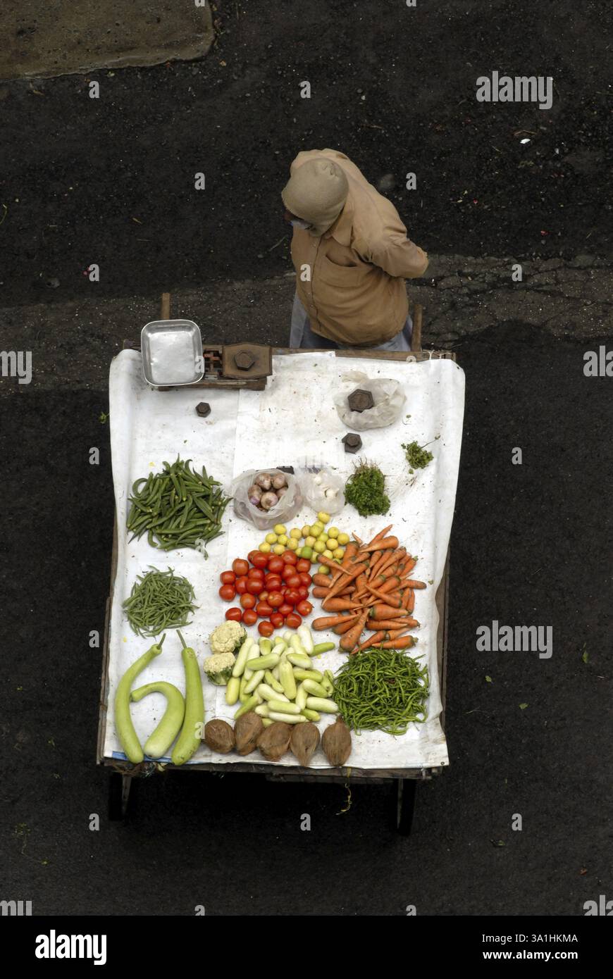 Aus der Vogelperspektive des Gemüseanbieters mit Handkarre voller verschiedenen Gemüsesorten, bekannt als Bhajiwala, Vitthalwadi, Pune, Maharashtra, Indien, Asien Stockfoto