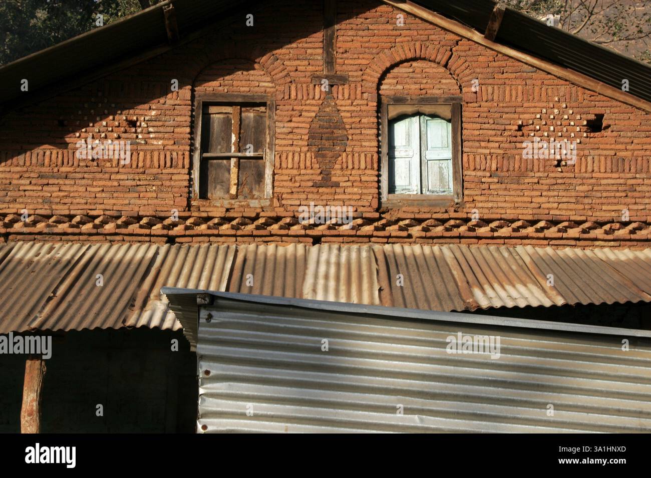 Abstraktes Haus mit Ziegelsteinen und Zinndächern und zwei Fenstern, ein grün gefärbt, Trambak, Nashik, Maharashtra, Indien, Asien Stockfoto
