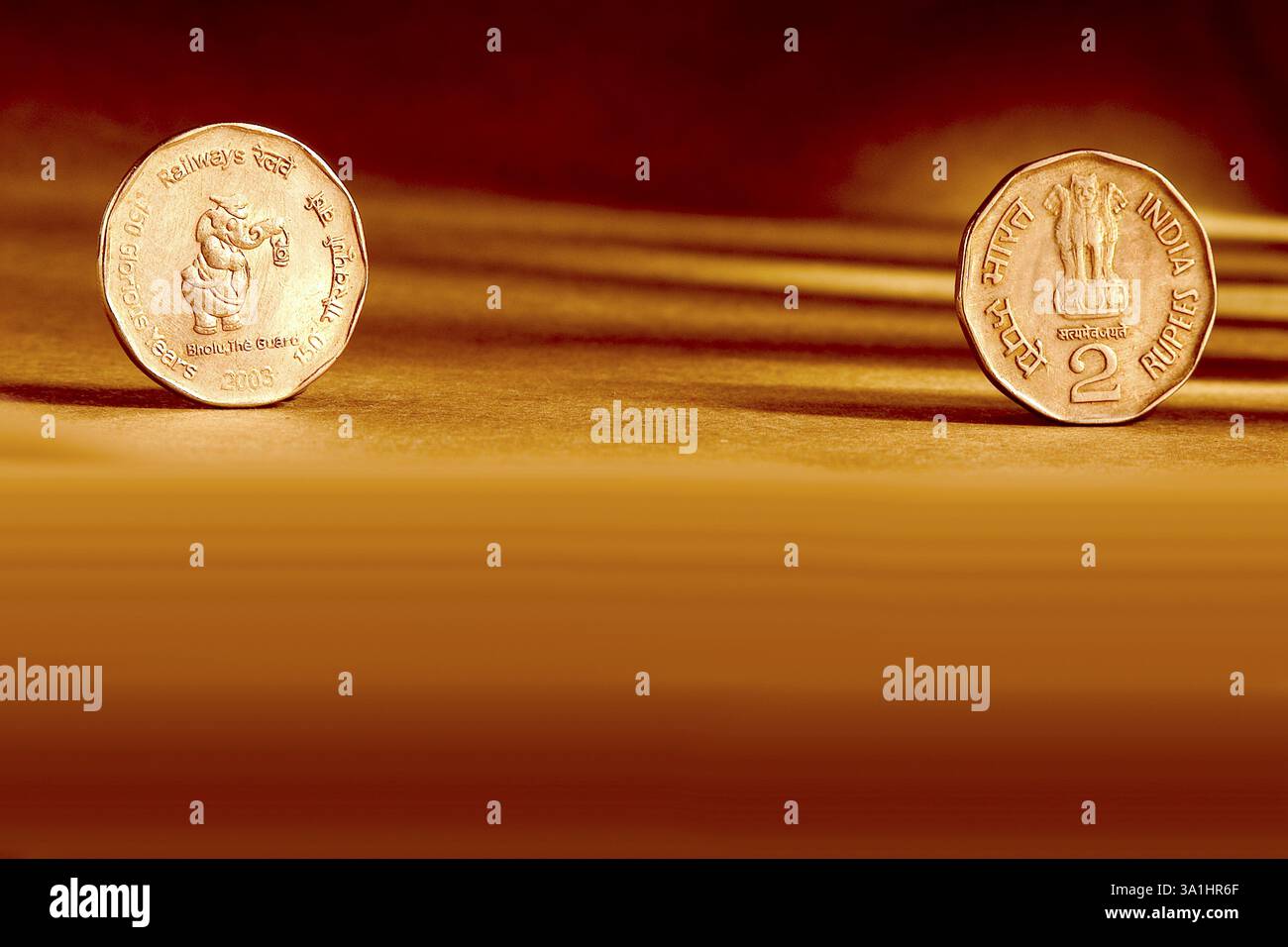 Doppelpaar indische Währung zwei Rupien Münze Vorder- und Rückseite Weise geprägte Eisenbahnen 150 glorreiche Jahre Bholu the Guard 2003 auf orange Rückseite Stockfoto