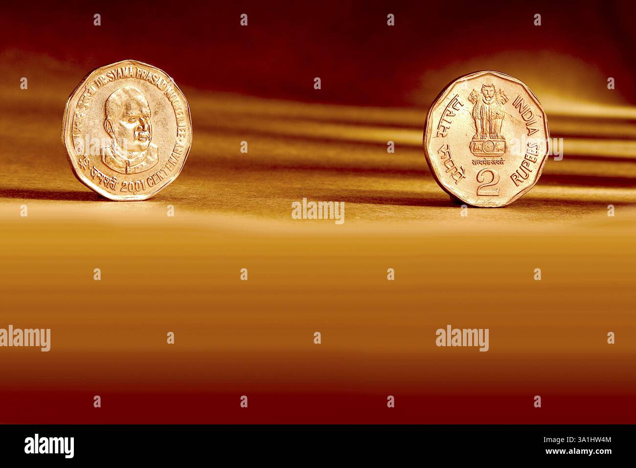 Doppelpaar indische Währung zwei Rupien Münzvorderseite und Rückseite geprägte Dr. Syama Prasad Mukherjee 2001 auf orangem Hintergrund Stockfoto