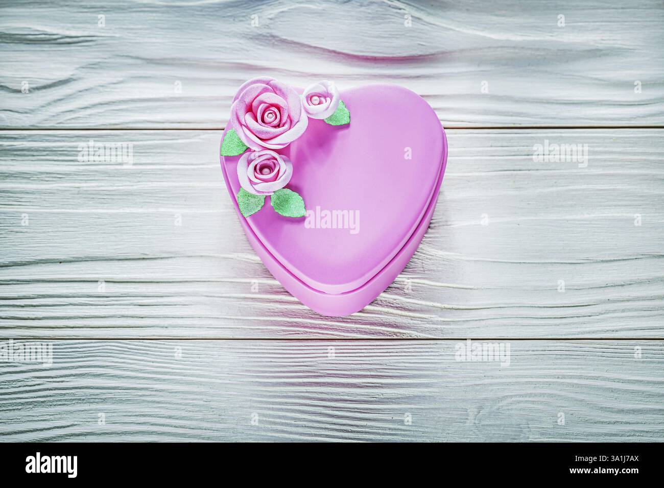 Herzförmige Geschenkbox auf Holzbrett-Feiertagskonzept Stockfoto
