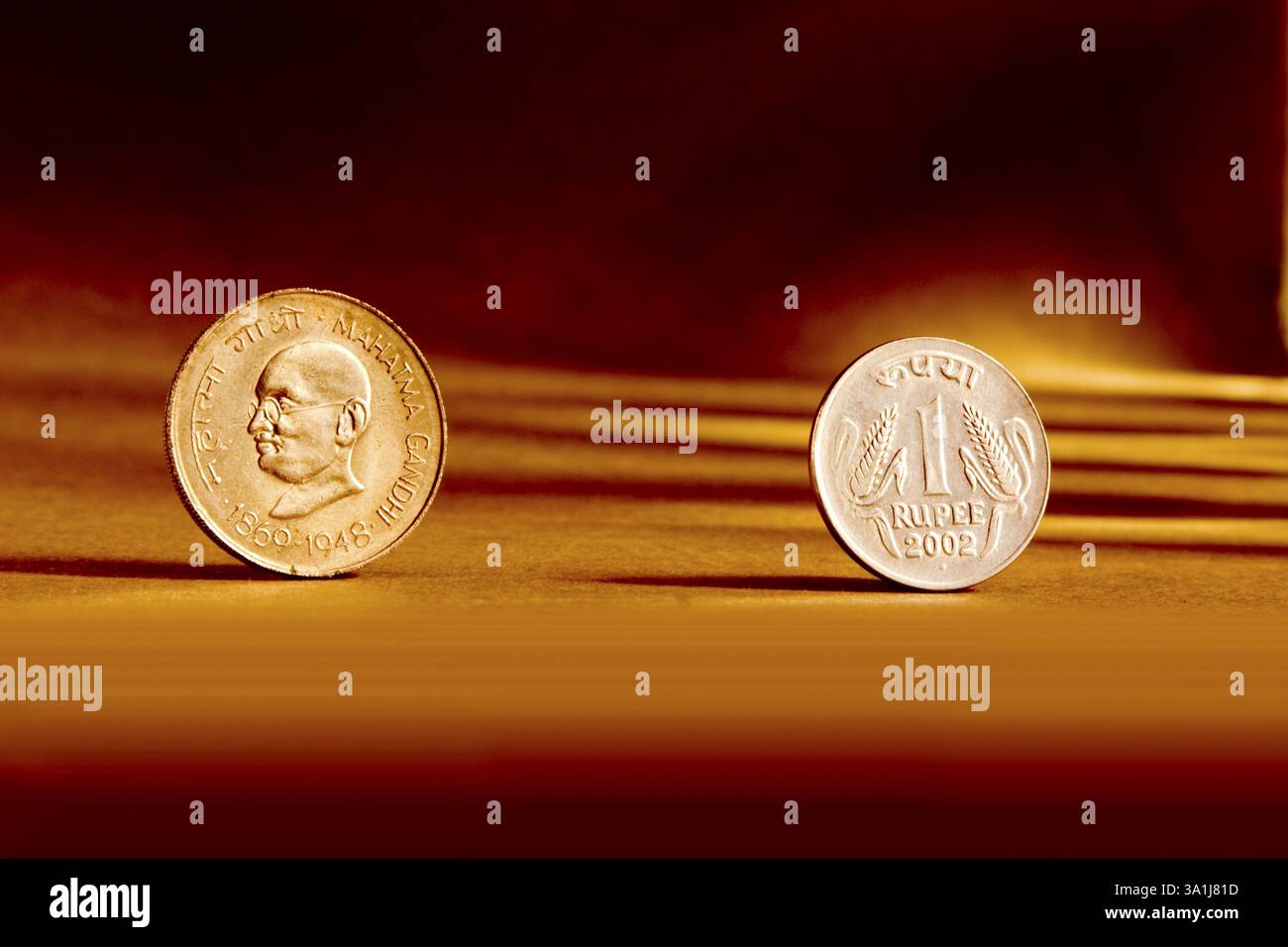 Doppeltes Paar indische Währung eine Rupie Münze Vorder- und Rückseite Weise geprägt Mahatma Gandhi 1869-1948 auf orangem Hintergrund Stockfoto