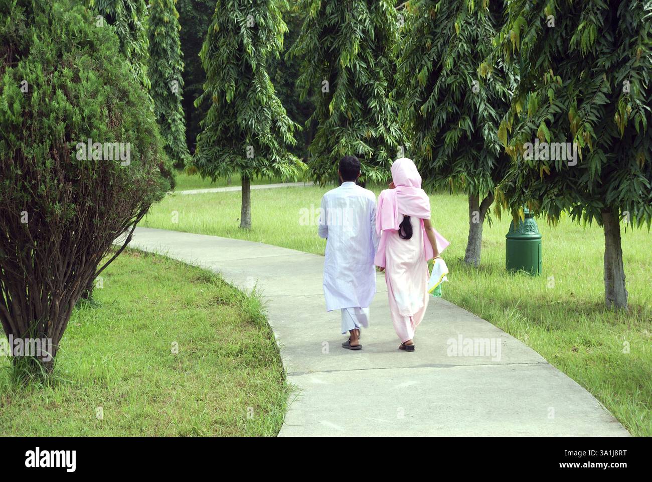 Mann und Frau zu Fuß auf Weg in Garten Stockfoto