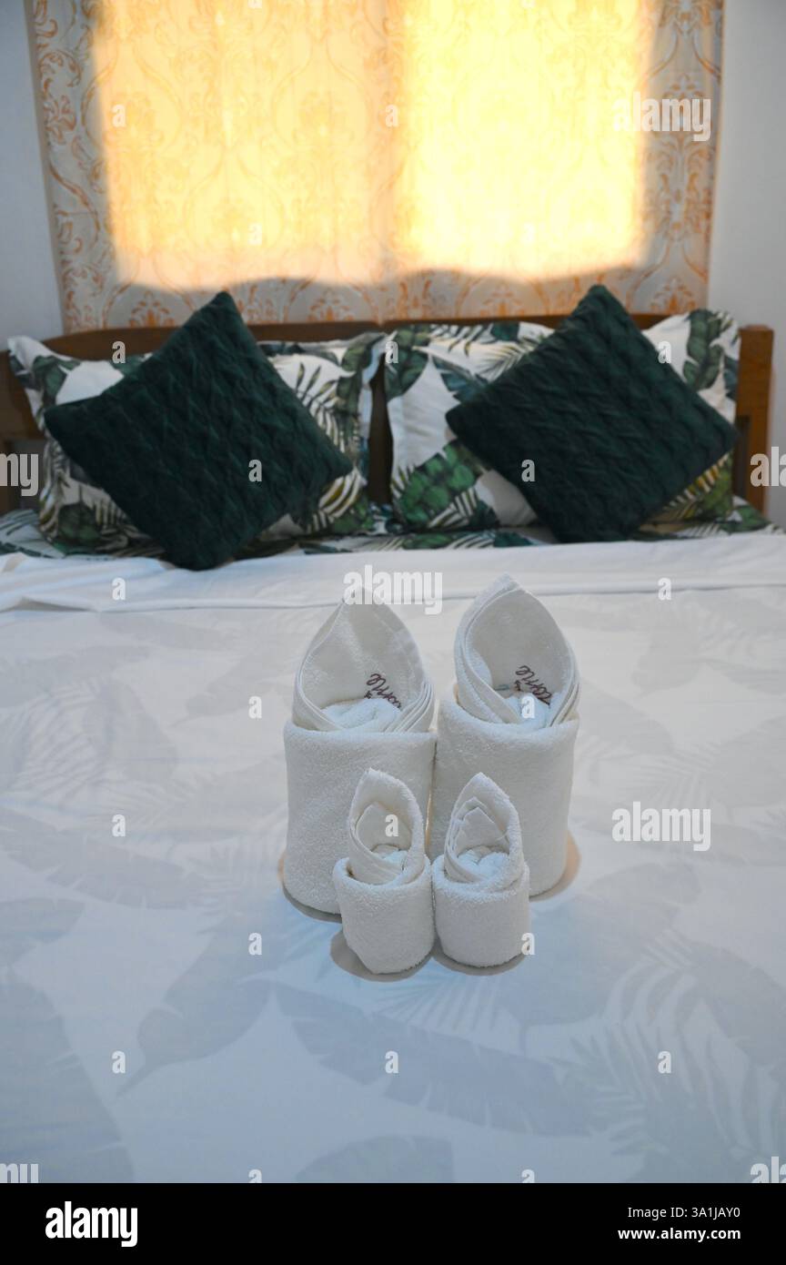 Philippinisches Hotelbett mit weißen Handtüchern. Stockfoto