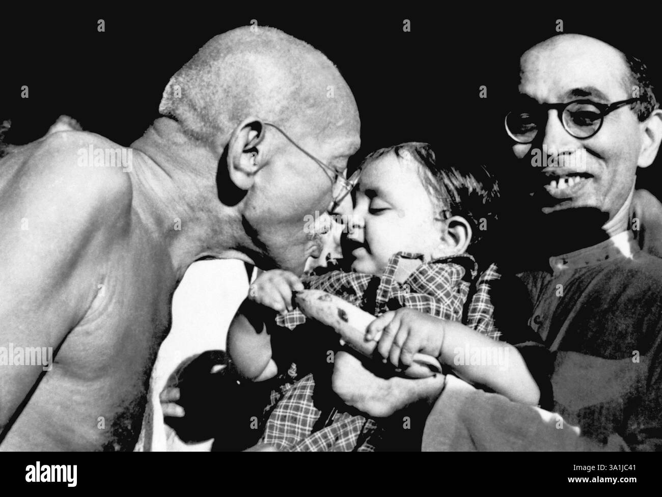 Mahatma Gandhi überreicht Nandini, Nichte von Pyarelal Nayar, ein Geburtstagsgeschenk im Sevagram Ashram, August 1944, Ashramite Anand Hingorani NA MR Stockfoto