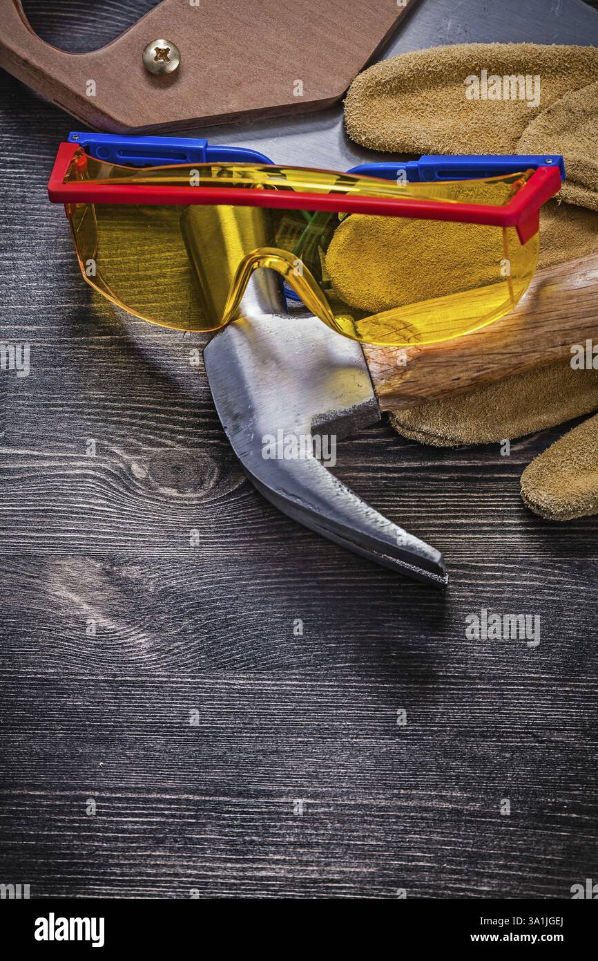 Handsäge Klauenhammer Schutzbrille Lederhandschuhe Stockfoto
