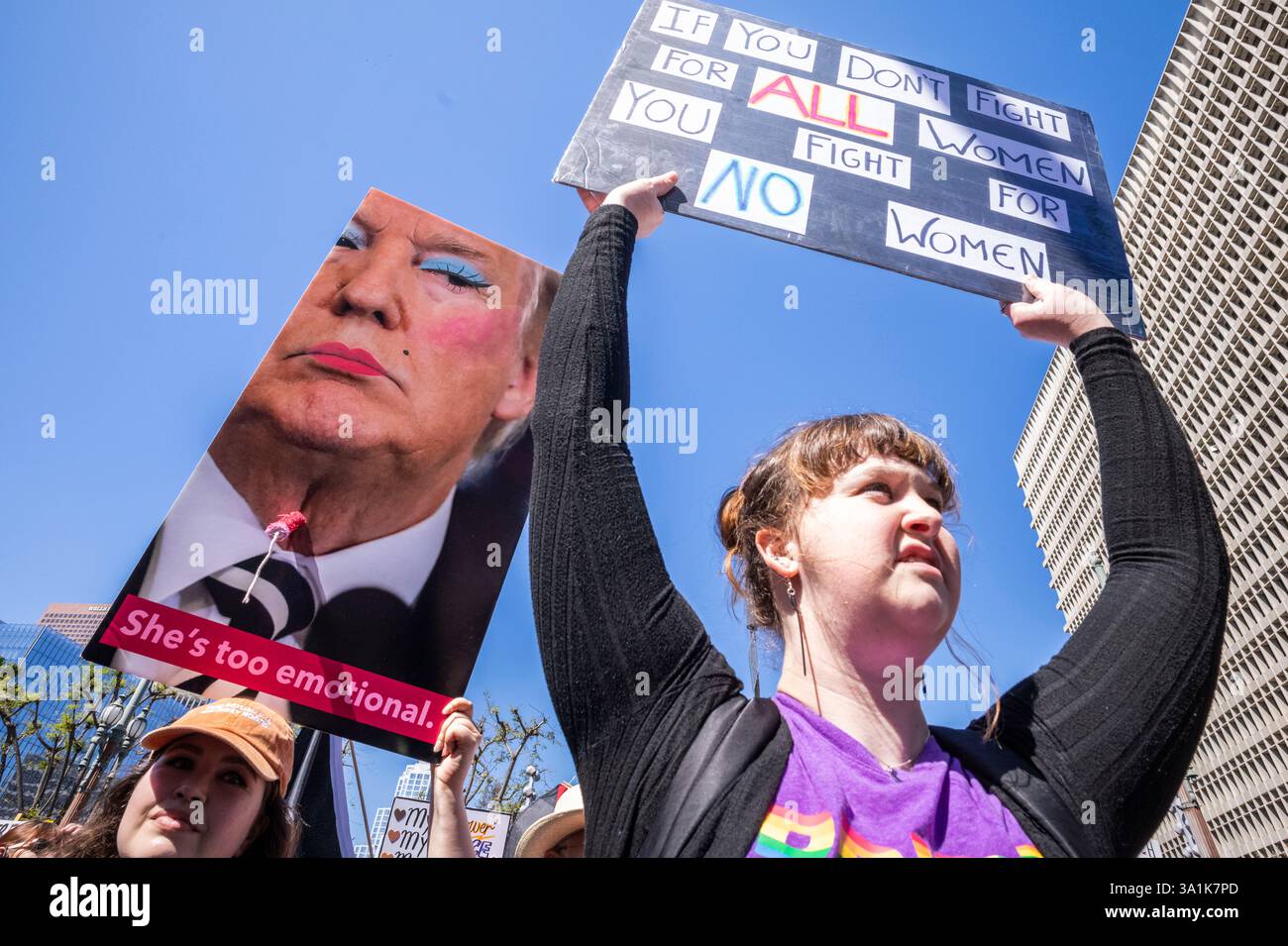 Los Angeles, Usa. März 2025. Die Demonstranten halten Plakate, die ihre Meinung zum Ausdruck bringen, während sie zum Frauenmarsch in Los Angeles auf den Straßen der Innenstadt von Los Angeles fahren. Quelle: SOPA Images Limited/Alamy Live News Stockfoto