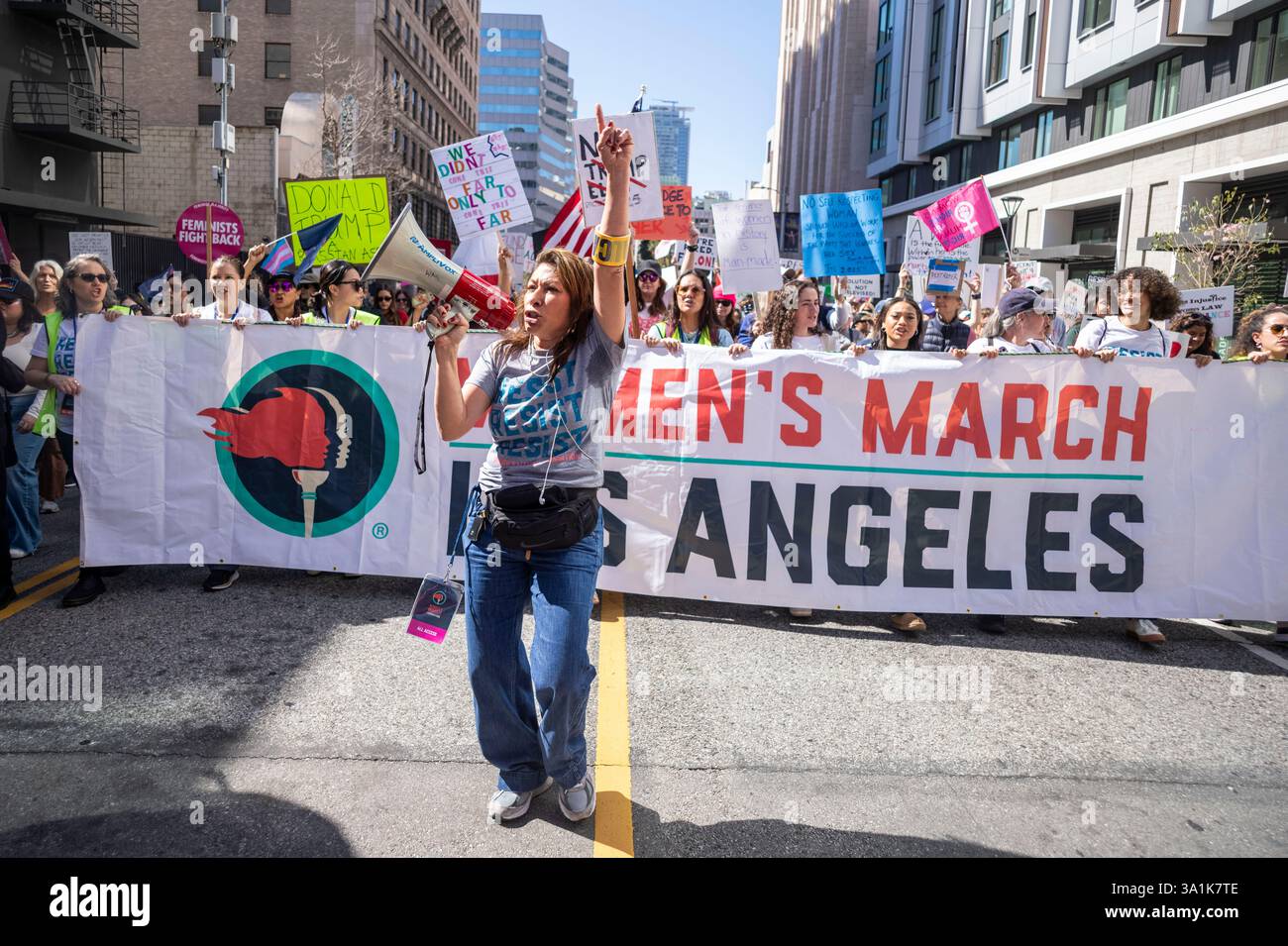 Los Angeles, Usa. März 2025. Ein Demonstrant führt Kollegen an, während sie zum Frauenmarsch in Los Angeles auf die Straßen der Innenstadt von Los Angeles gehen. Quelle: SOPA Images Limited/Alamy Live News Stockfoto