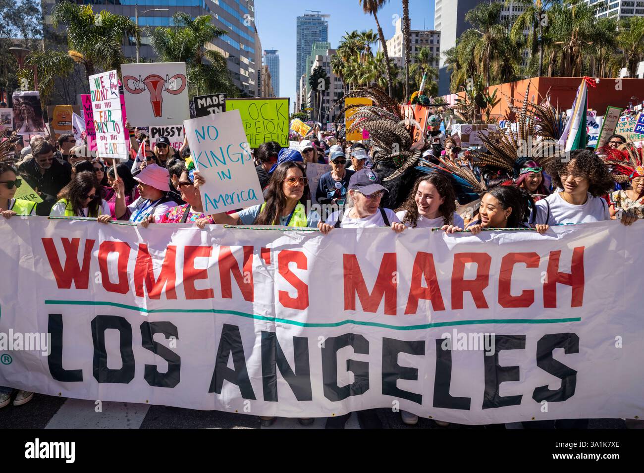Los Angeles, Usa. März 2025. Die Demonstranten halten Plakate und ein Banner, während sie zum Frauenmarsch in Los Angeles auf die Straßen der Innenstadt von Los Angeles gehen. Quelle: SOPA Images Limited/Alamy Live News Stockfoto