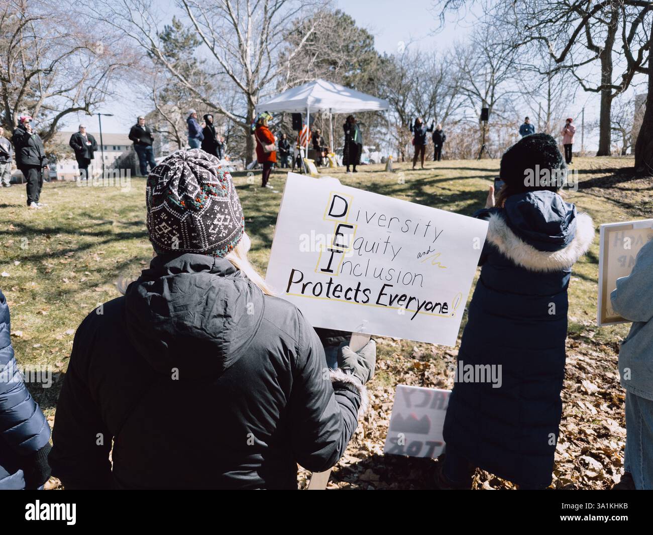Eine Frau, die ein Schild mit der Aufschrift Diversity Equity Inclusion Protected Everyone hält, bei der International Women's Day Rally, Flint Michigan USA, 8. März 2025 Stockfoto