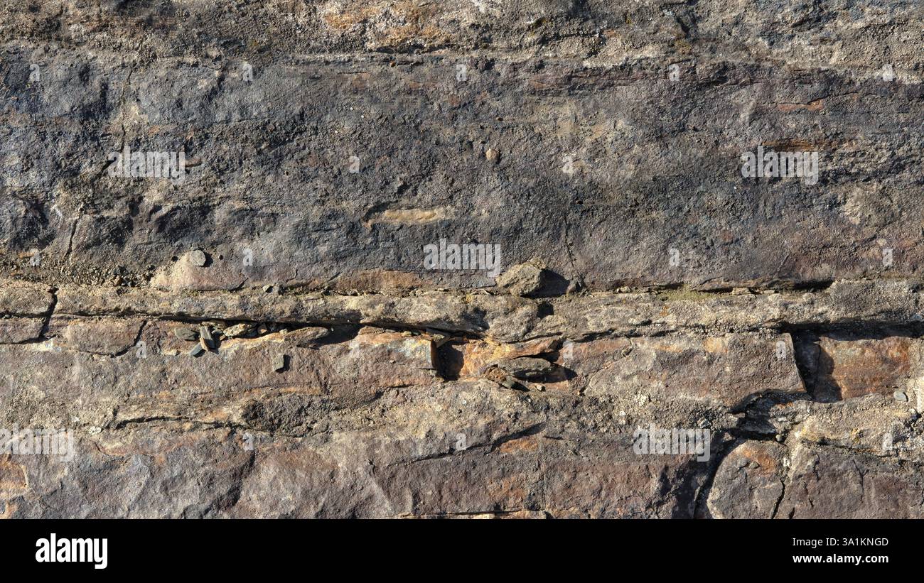 Breiter Hintergrund der Steinoberfläche, bedeckt mit Rissen und Unebenheiten Stockfoto